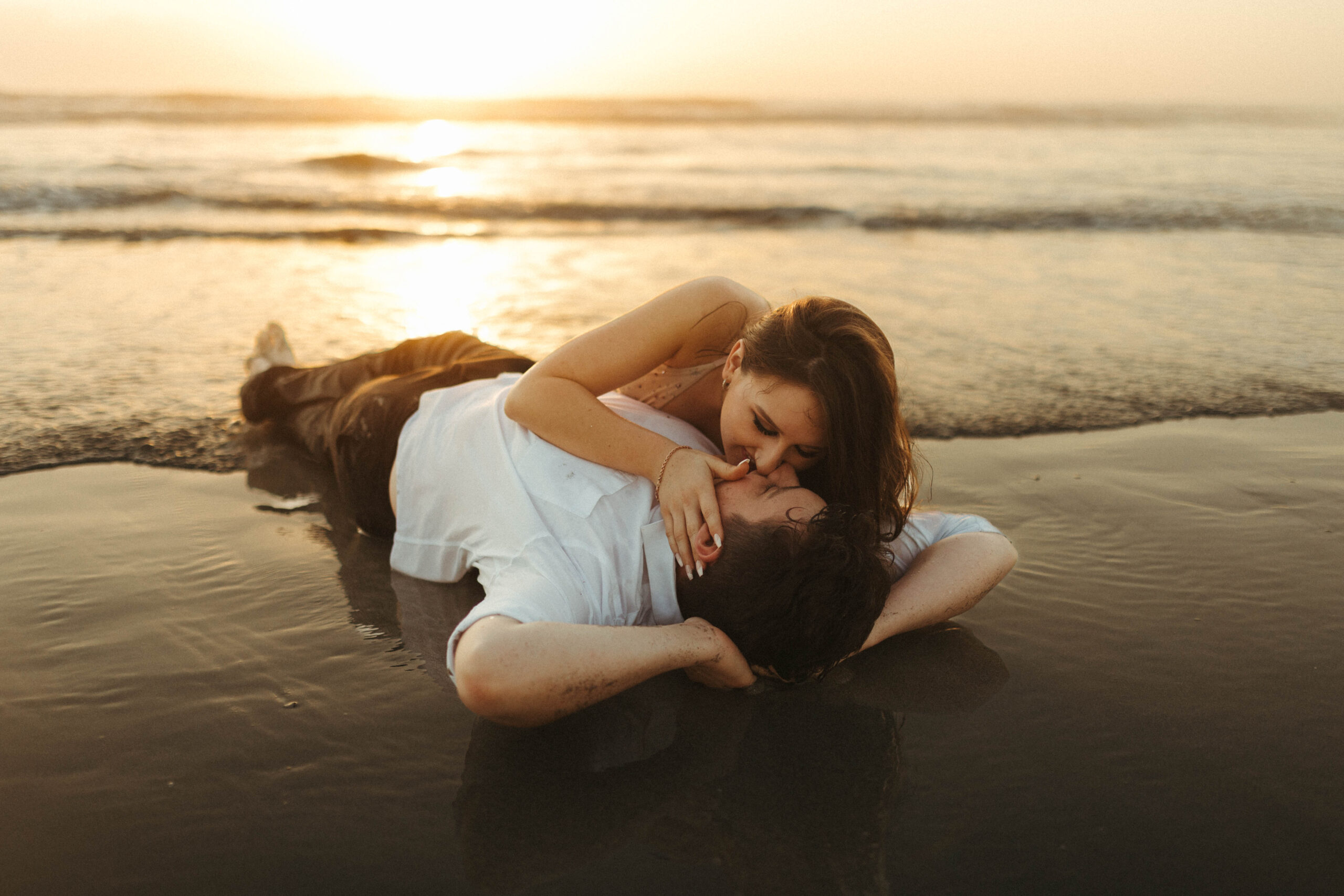 Couple laying on the beach at sunrise
