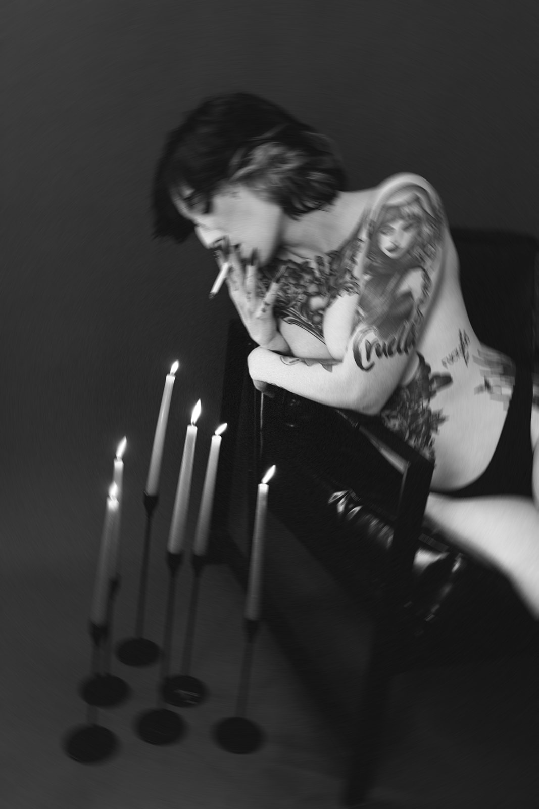 A girl using candles to light a cigarette in her boudoir photos