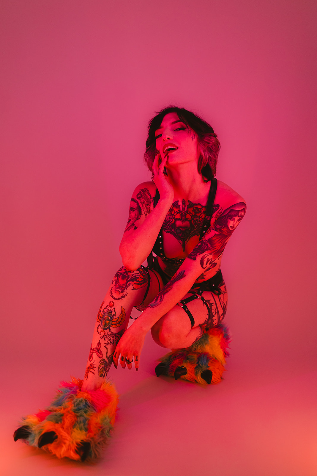 A girl wearing slippers and sitting on the ground during a boudoir photoshoot