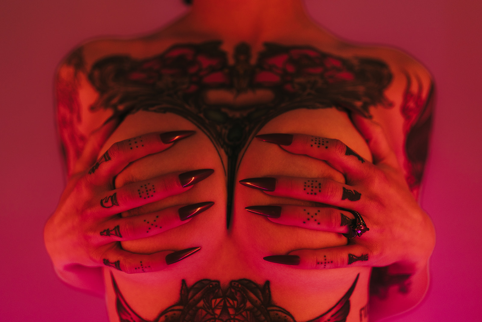 A boudoir photoshoot pose idea, with a topless woman holding her chest