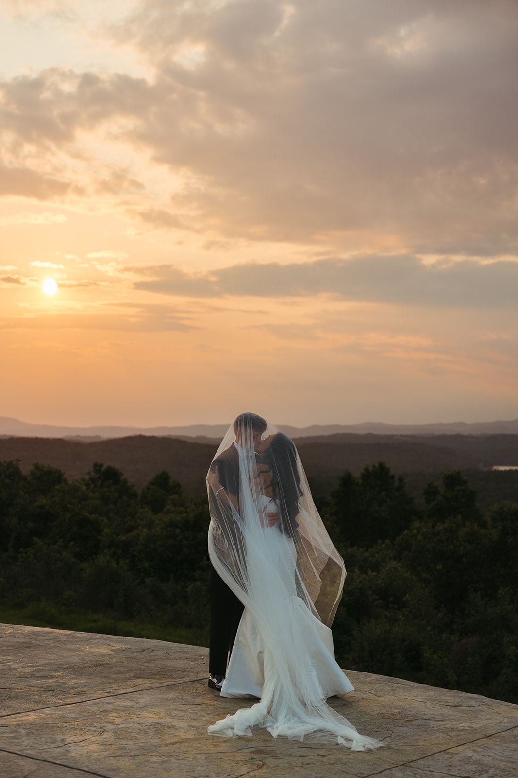 Bride and groom sunset photos underneath a veil