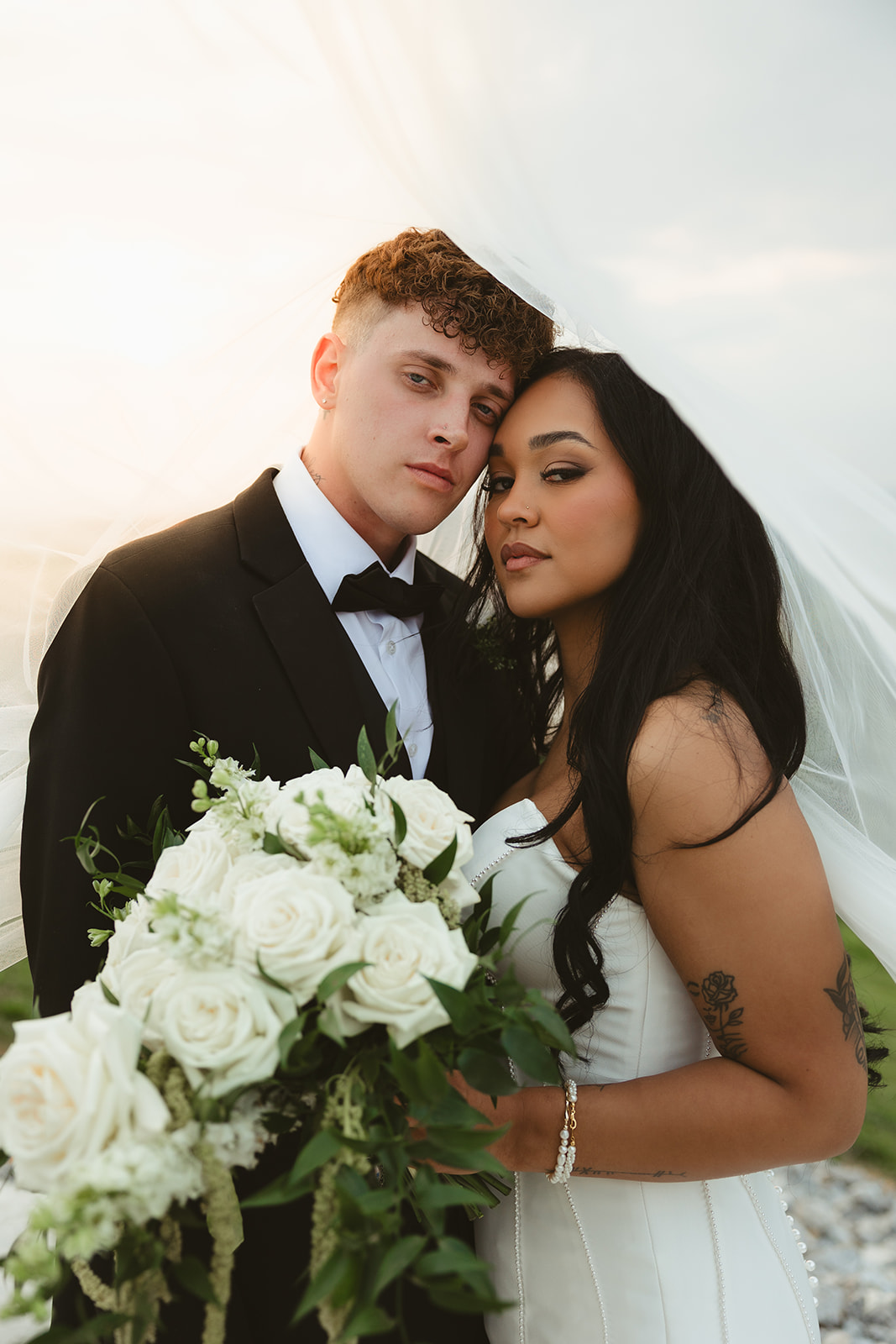 Bride and groom posing for an editorial wedding veil photo