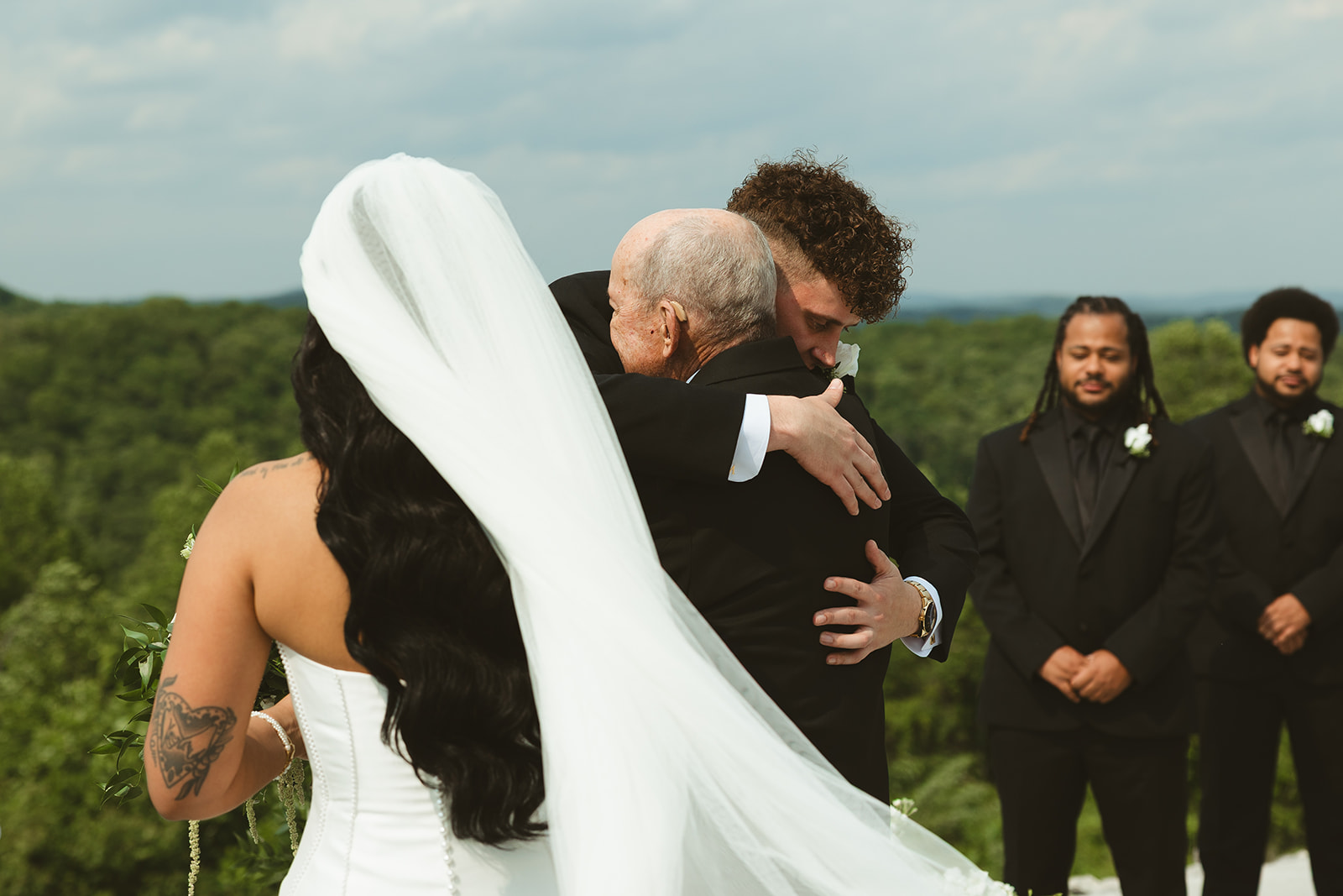 Groom hugging his bride's grandfather meeting him at the aisle