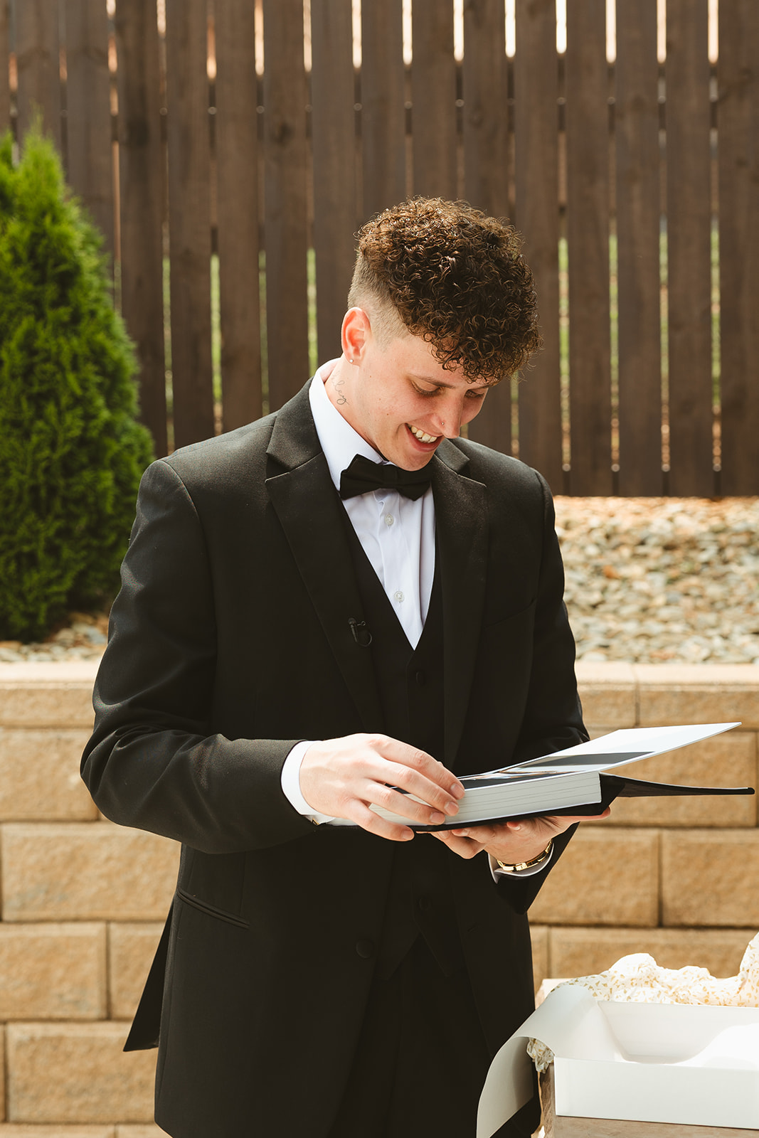 Groom looking at bride's wedding gift: a book of boudoir photos