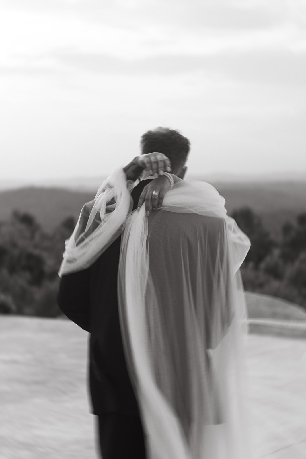 Bride and groom slow dancing with veil wrapped around groom