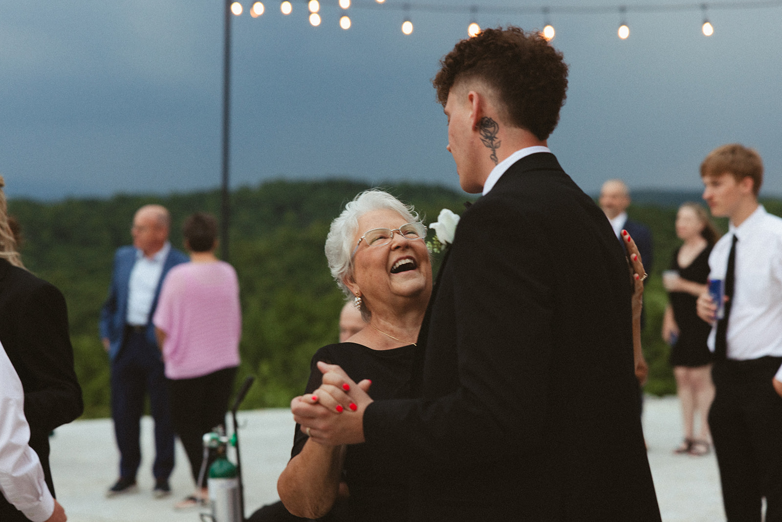 Groom dancing with bride's grandmother at wedding reception