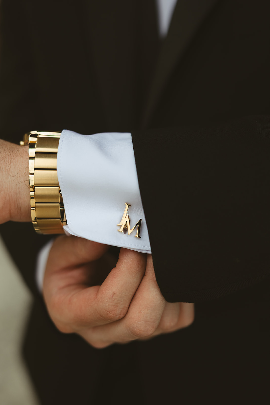 Groom putting on his cuff link during getting ready wedding photos