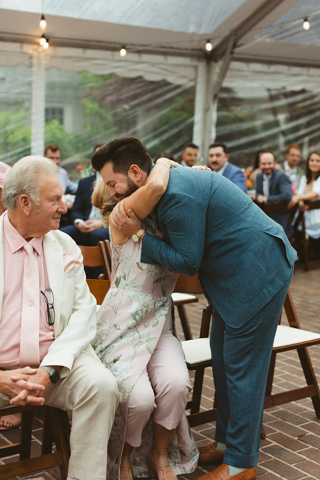 A groom hugging a wedding guest at a wedding ceremony