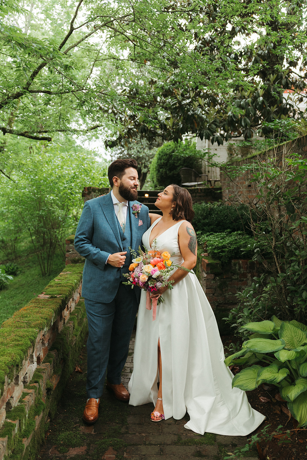 A bride and groom walking through the gardena t Maple Grove estate, with the bridal bouquet and wedding shoes giving colorful wedding ideas