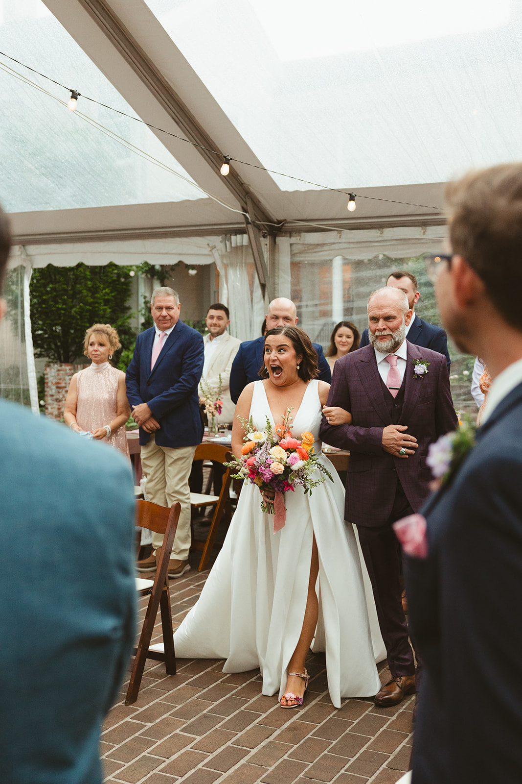 A bride smiling while walking down the aisle