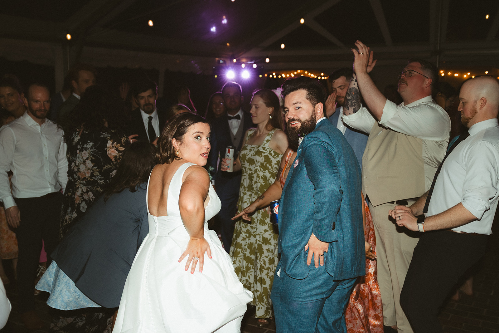 A candid wedding reception photo of a couple dancing