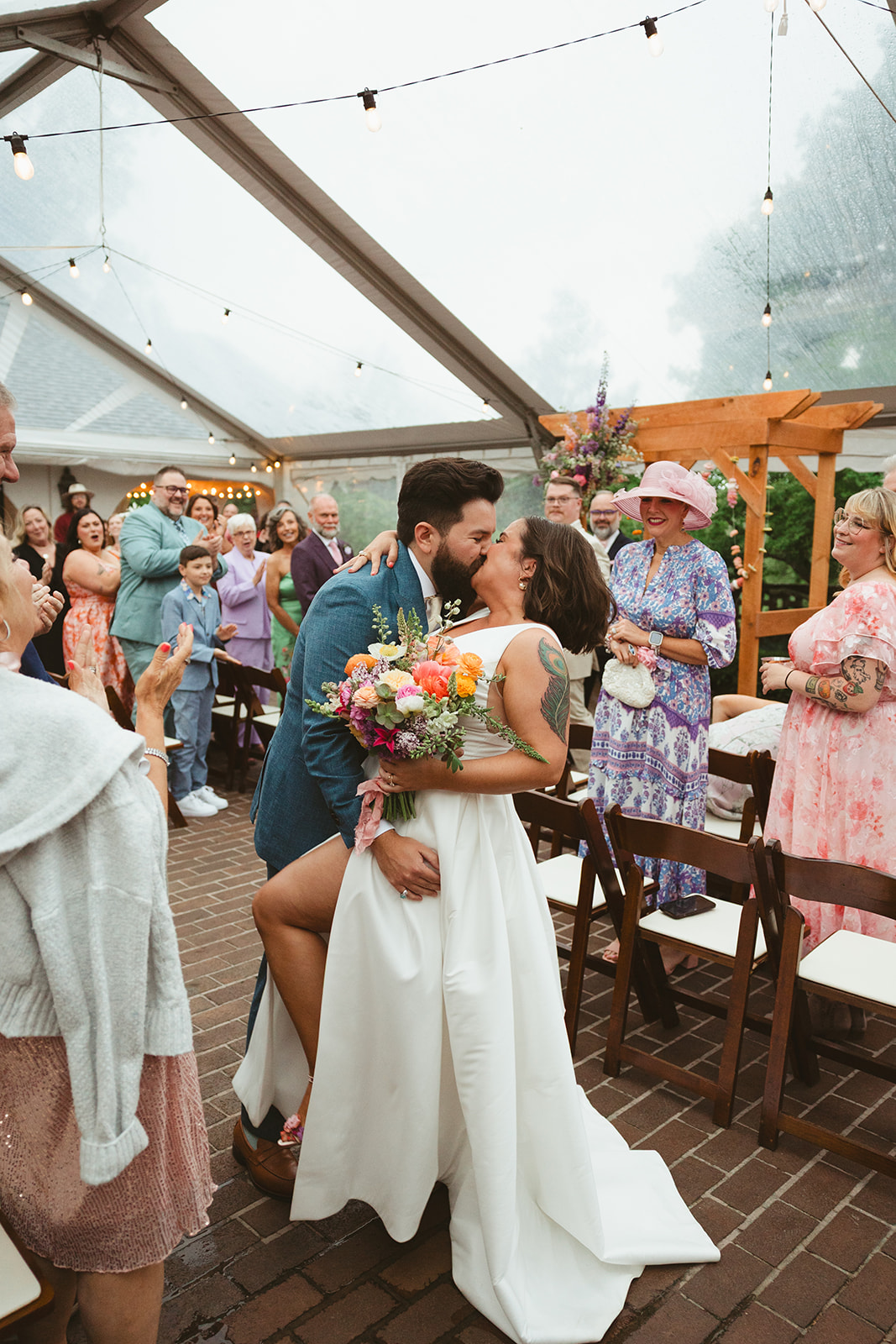 A bride and groom kissing a ttheir wedding ceremony that was full of colorful wedding ideas