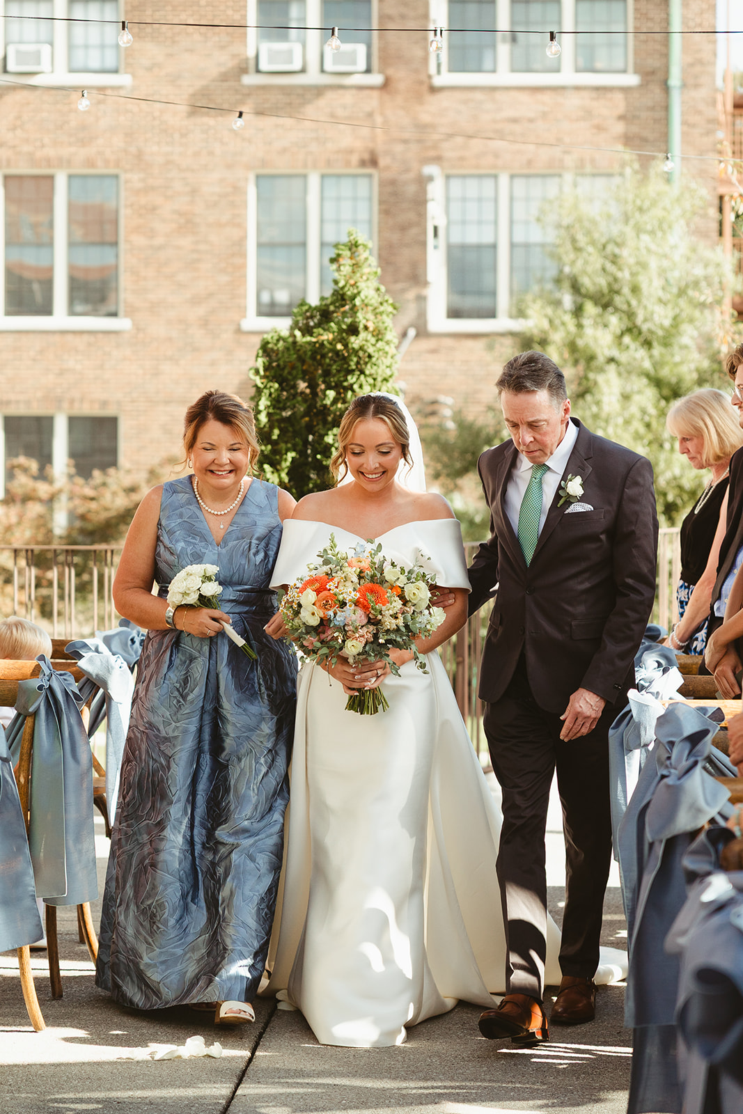 A bride walking down the aisle with her parents