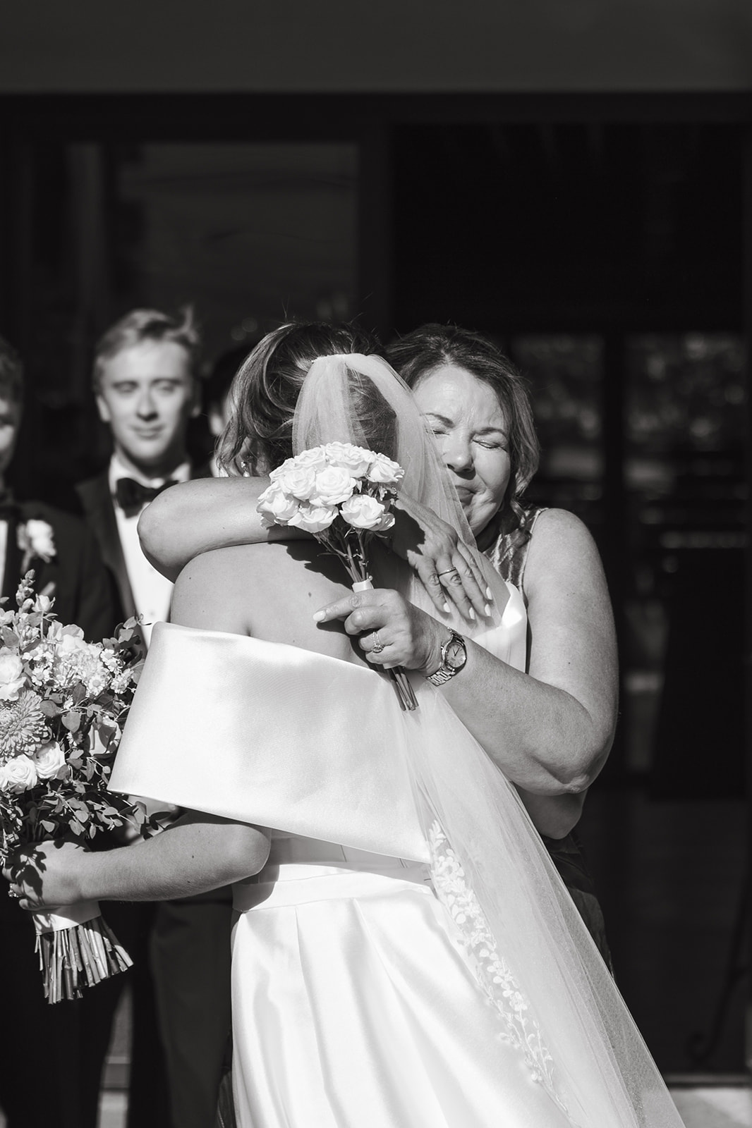 A bride hugging a wedding guest captured through documentary style wedding photography