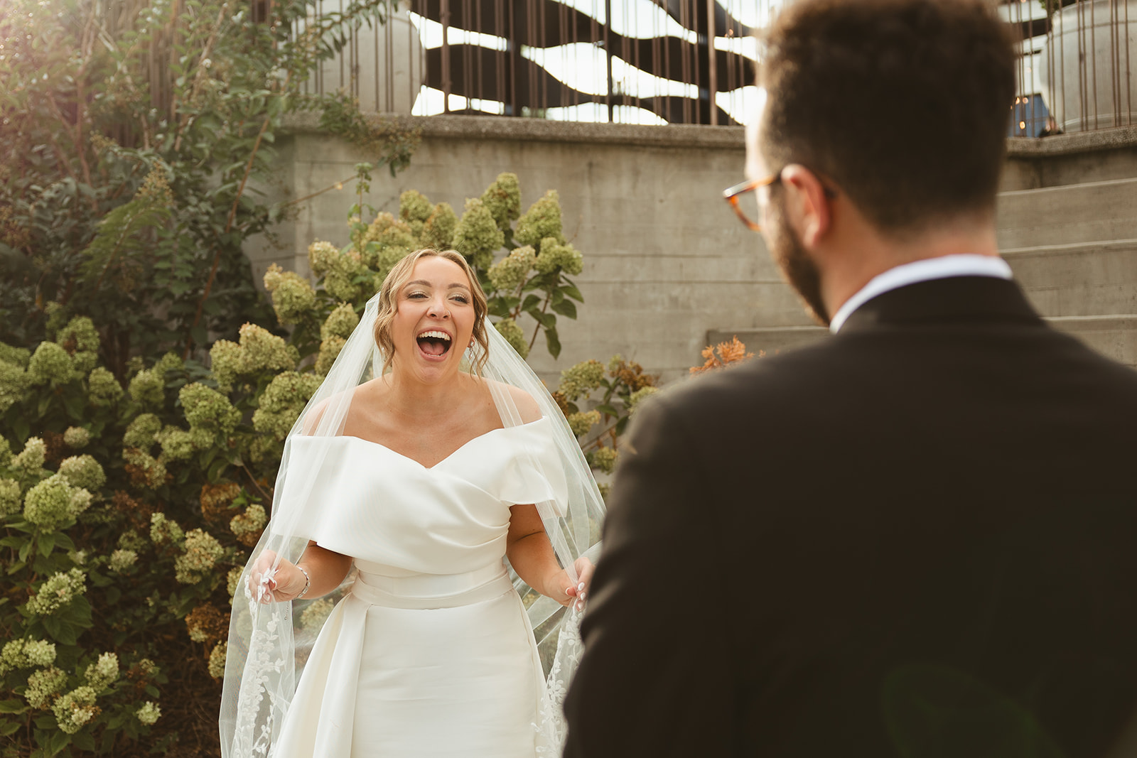 A candid photo of a bride laughing at a groom captured through documentary style wedding photography
