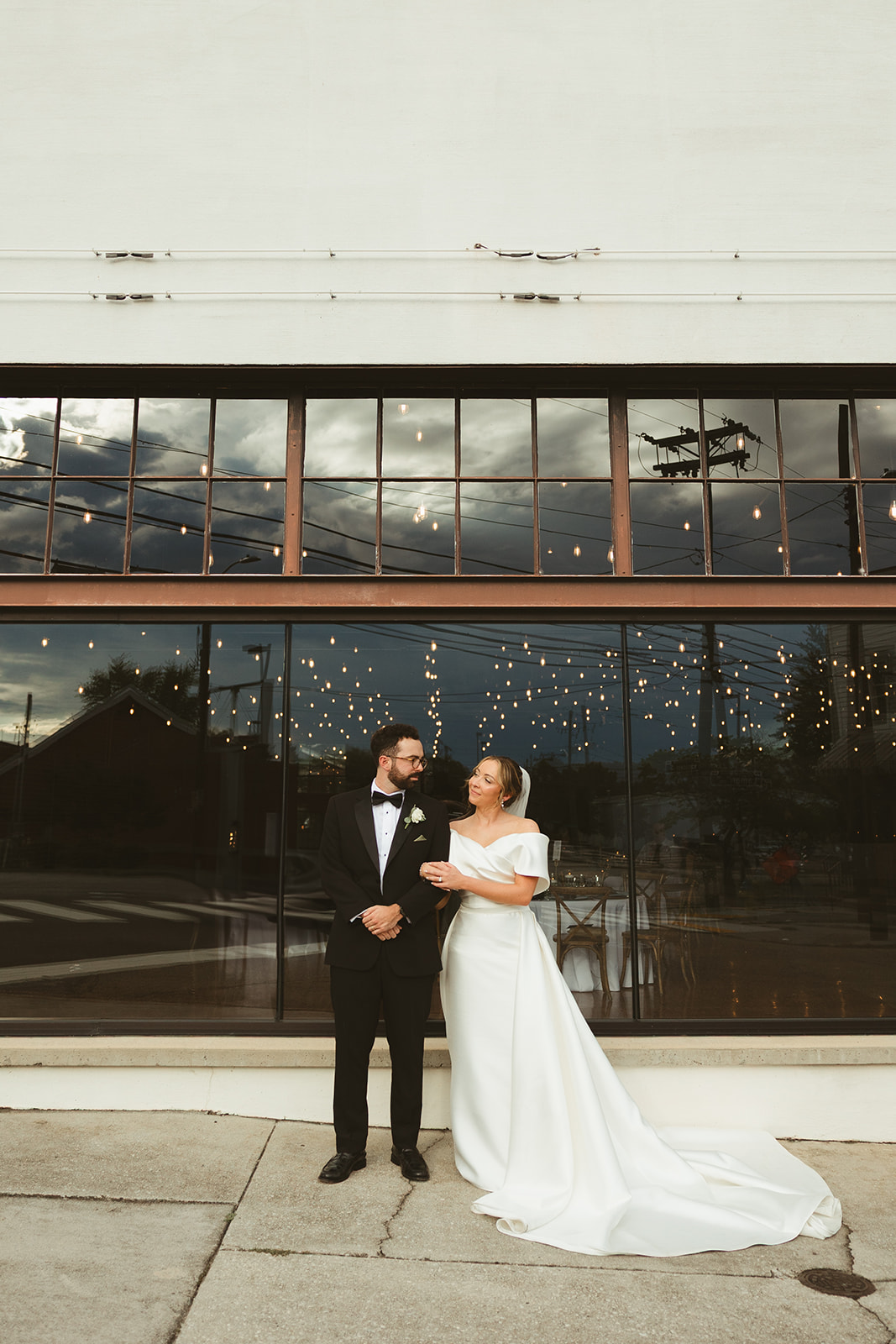 A bride and groom smiling at each other for wedding photos