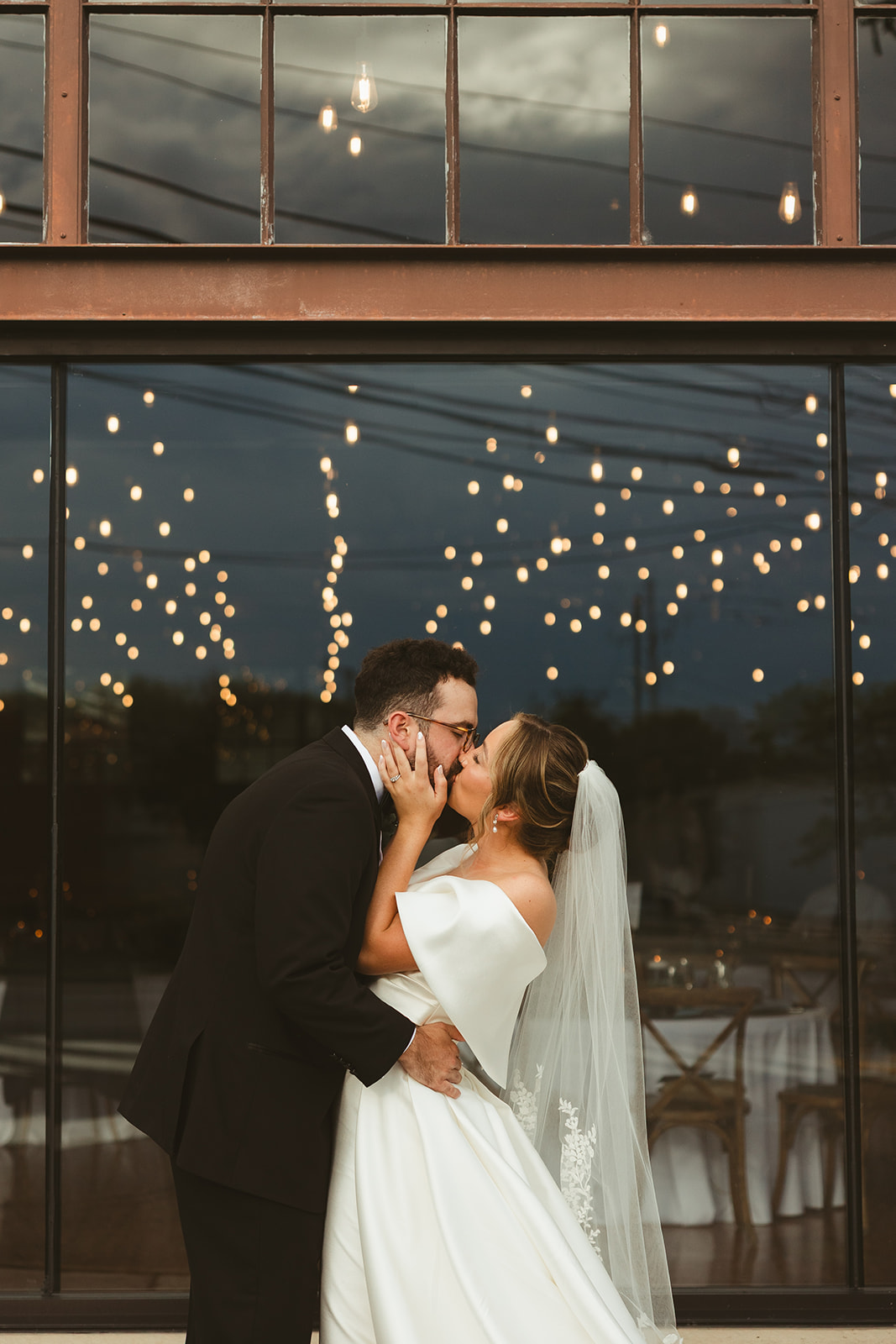 A bride and groom kissing in wedding portraits