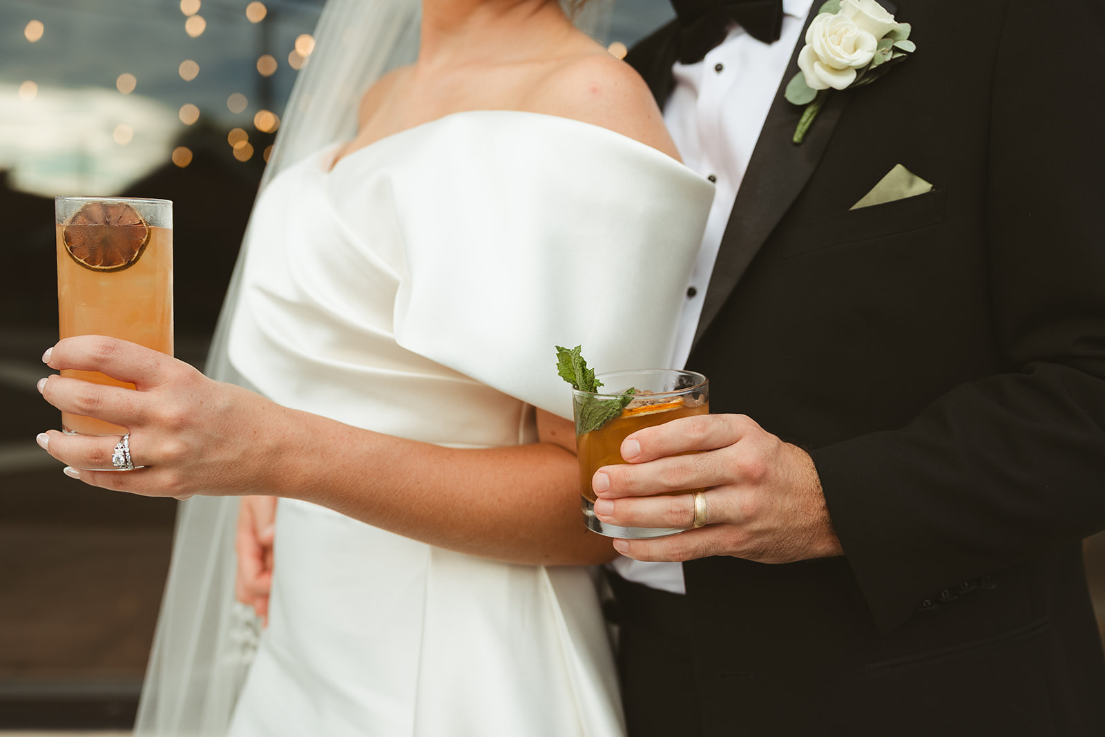 A wedding photo of a bride and groom holding drinks captured through documentary style wedding photography