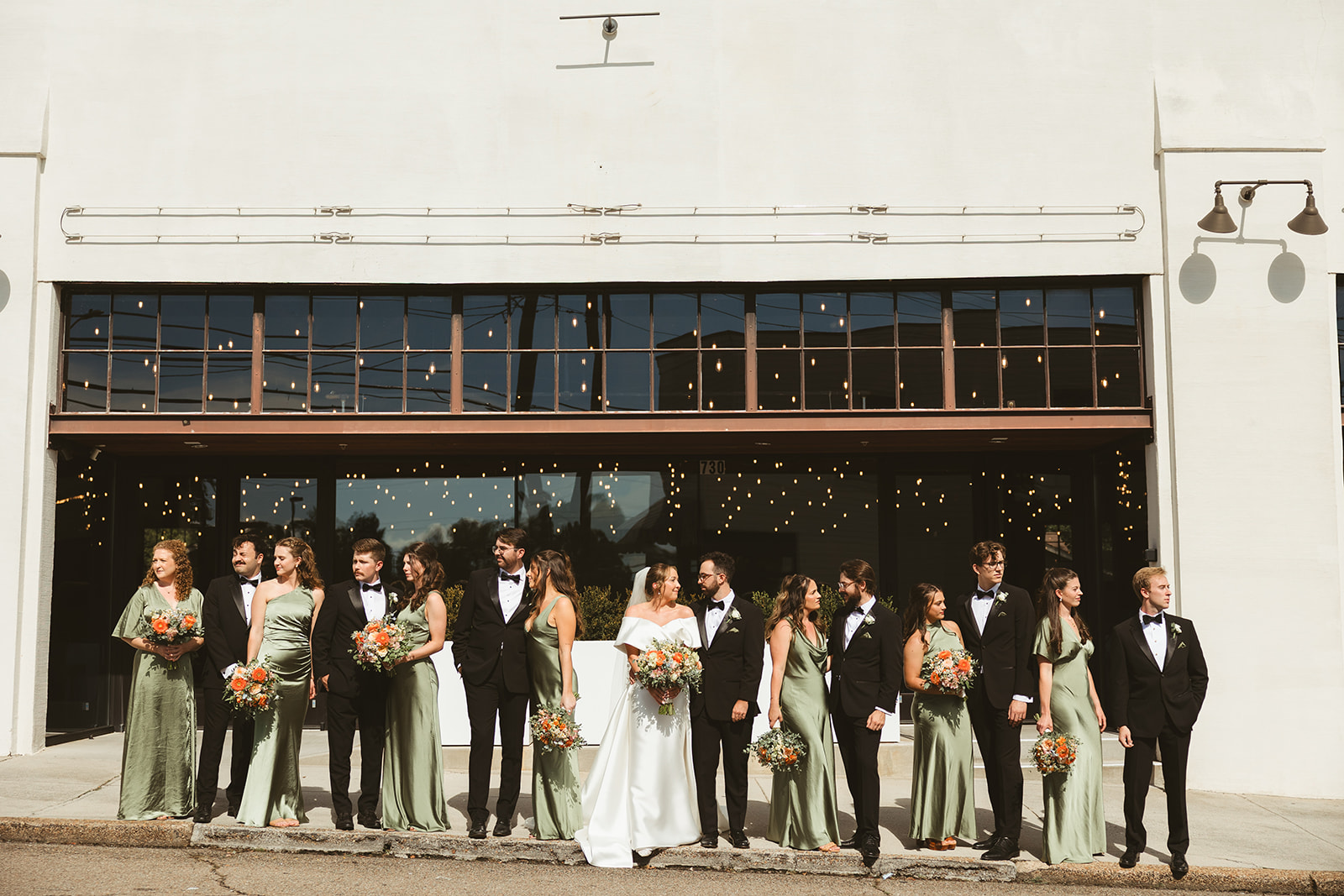 A wedding party posing for wedding photos on the street