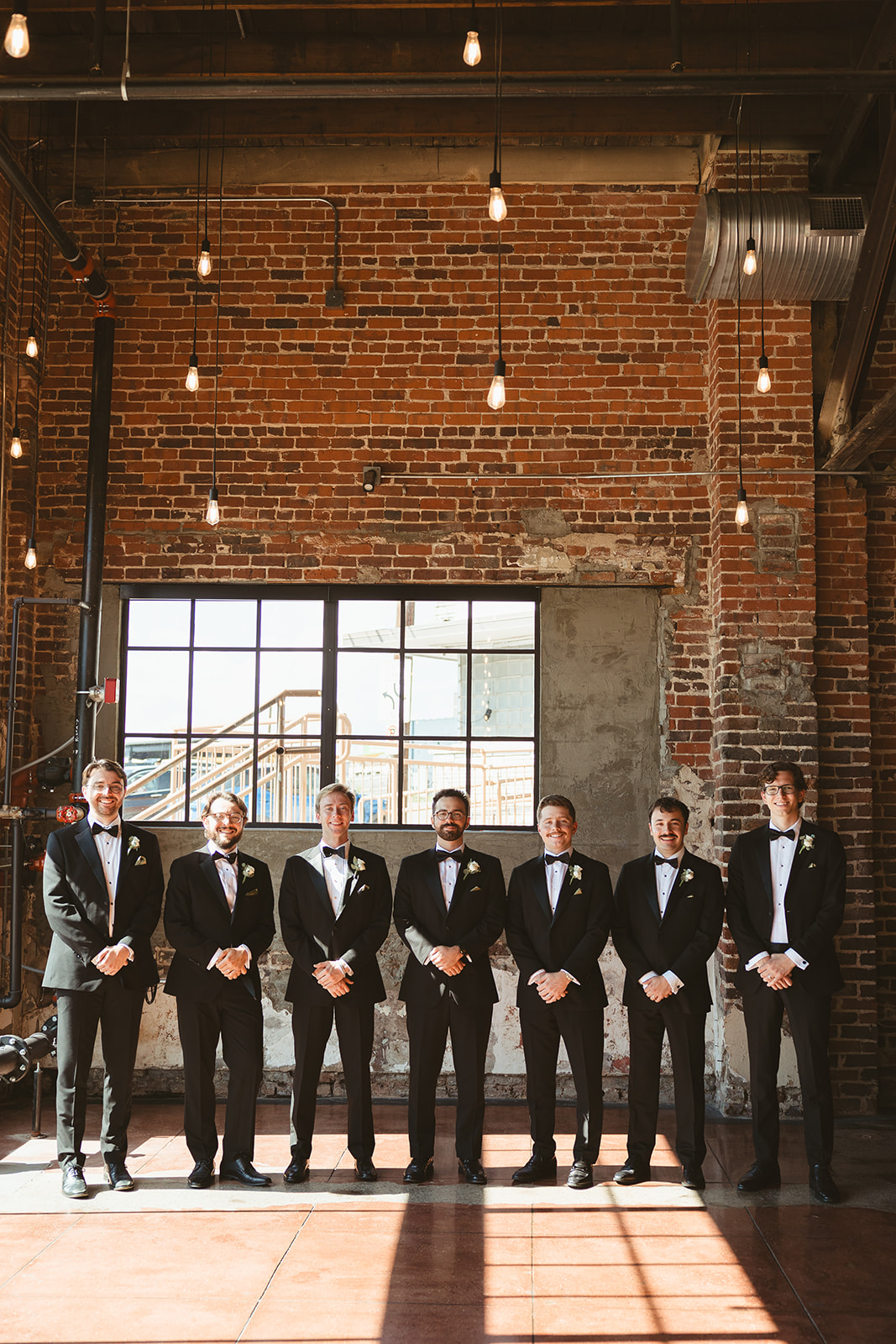A groom posing for wedding photos with his groomsmen