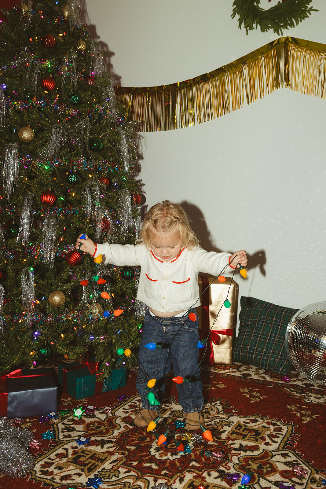 A little girl holding christmas lights for christmas photo ideas