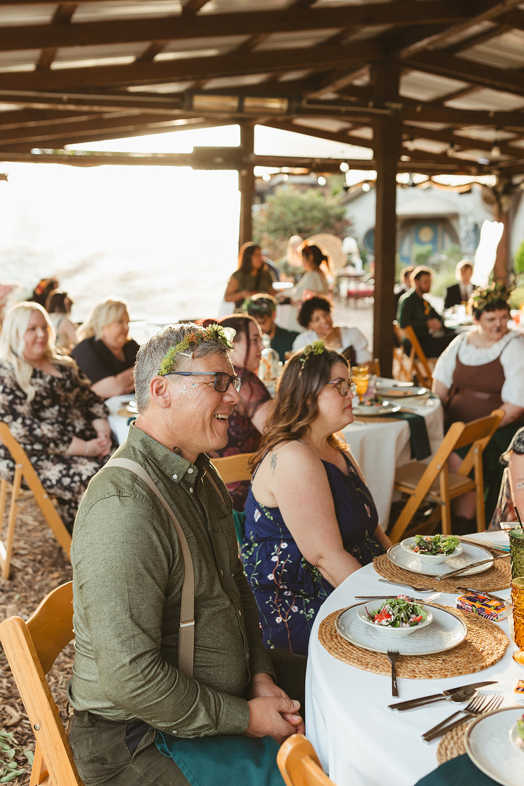 A wedding guest sitting with a fairy crown on his head