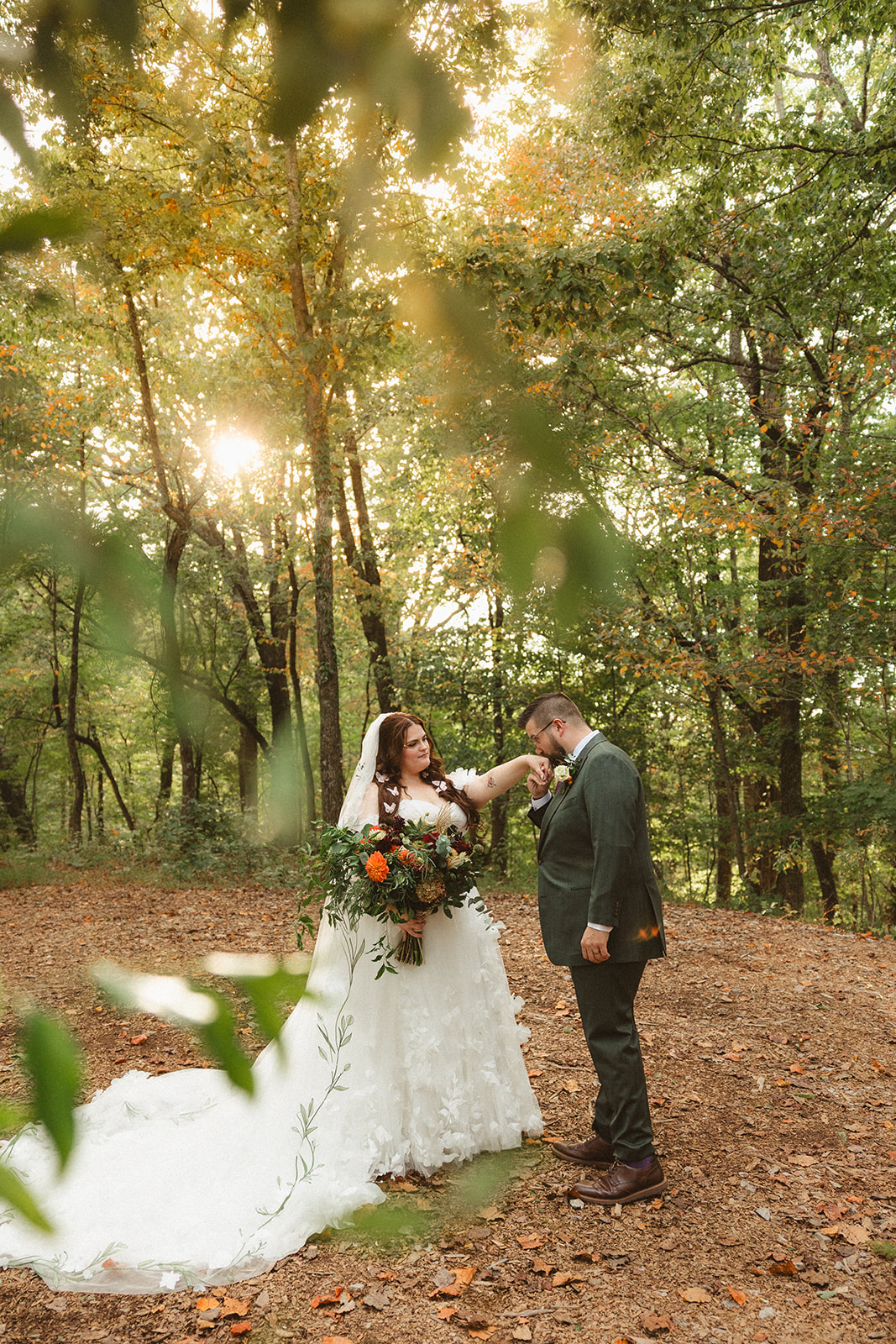 A bride and groom taking photos in the woods at Ancient Lore Village