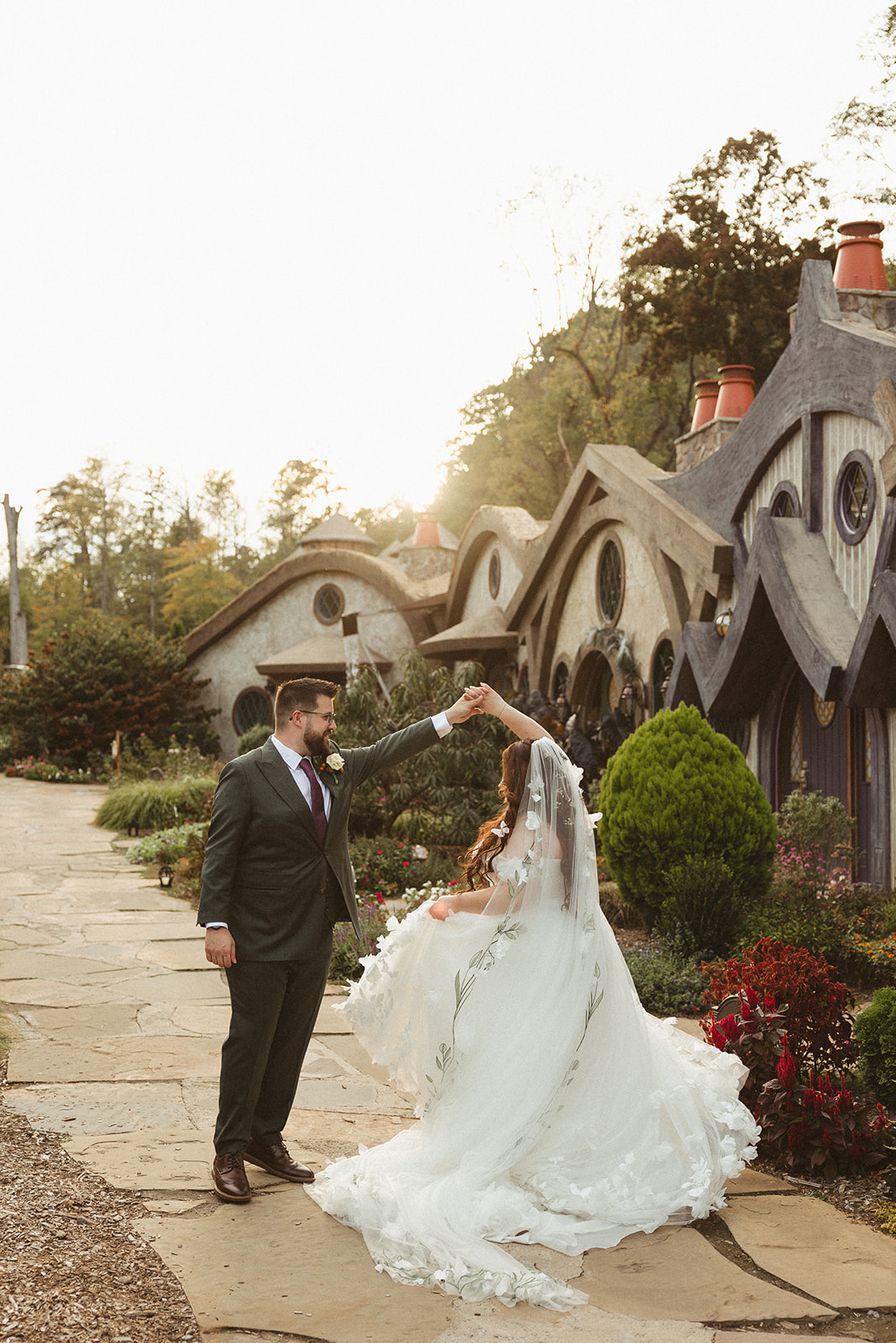 A bride and groom spinning during wedding photos at ancient lore village