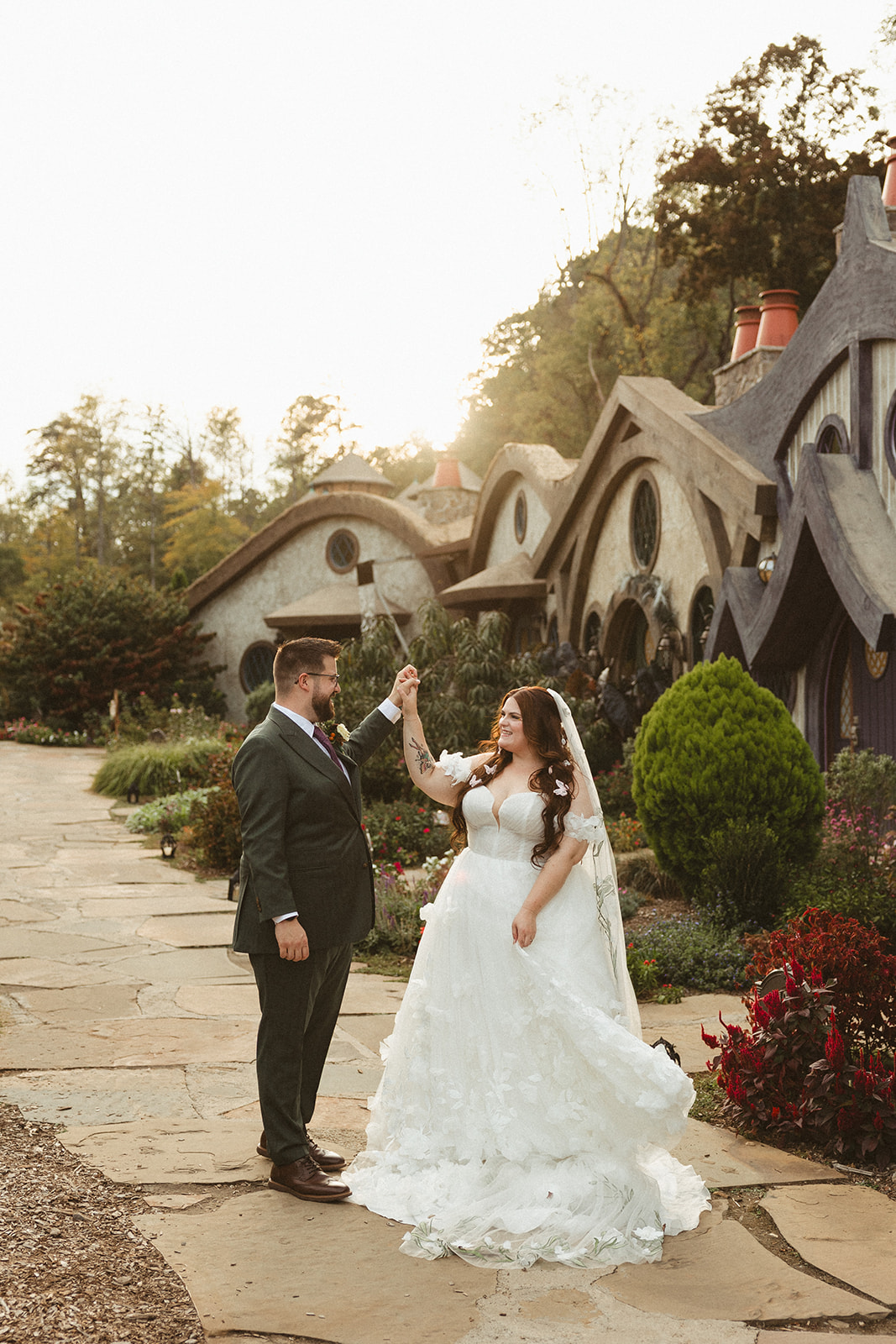 A bride and groom spinning during wedding photos at ancient lore village