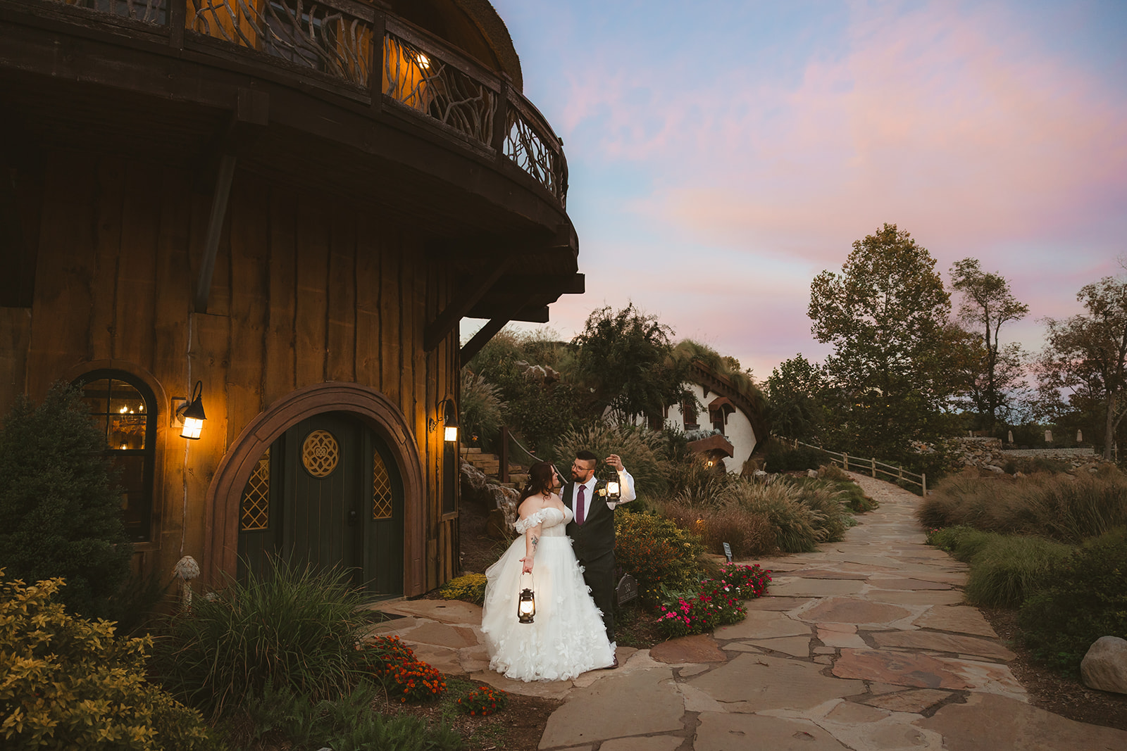 A bride and groom holding lanterns and walking through Knoxville wedding venue, Ancient Lore Village