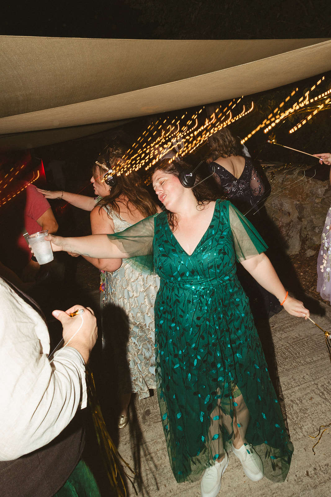 A candid photo of a wedding guest dancing during a silent disco