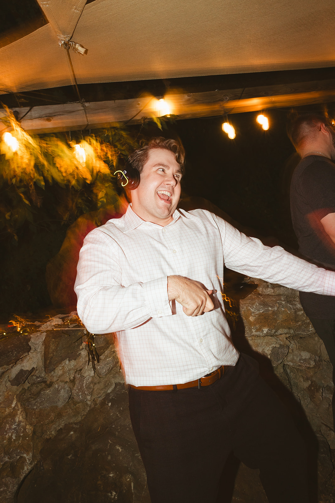 A candid photo of a wedding guest dancing during a silent disco