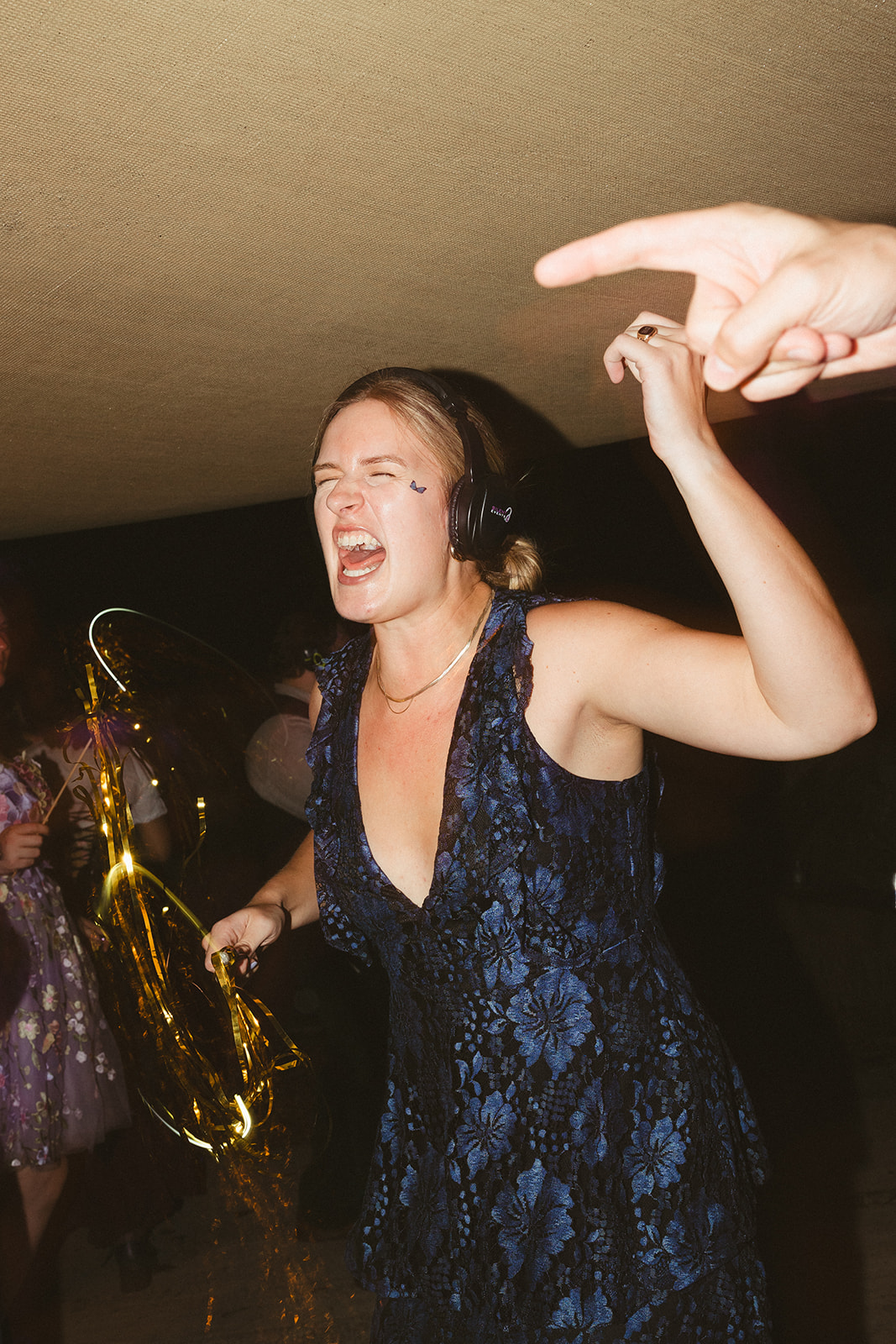 A candid photo of a wedding guest dancing during a silent disco