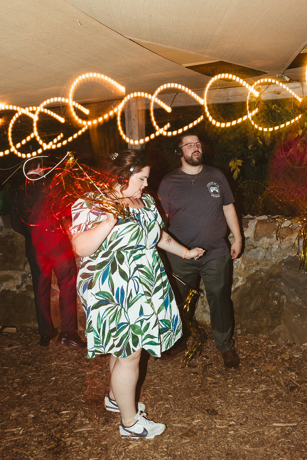 A candid photo of a wedding guest dancing during a silent disco