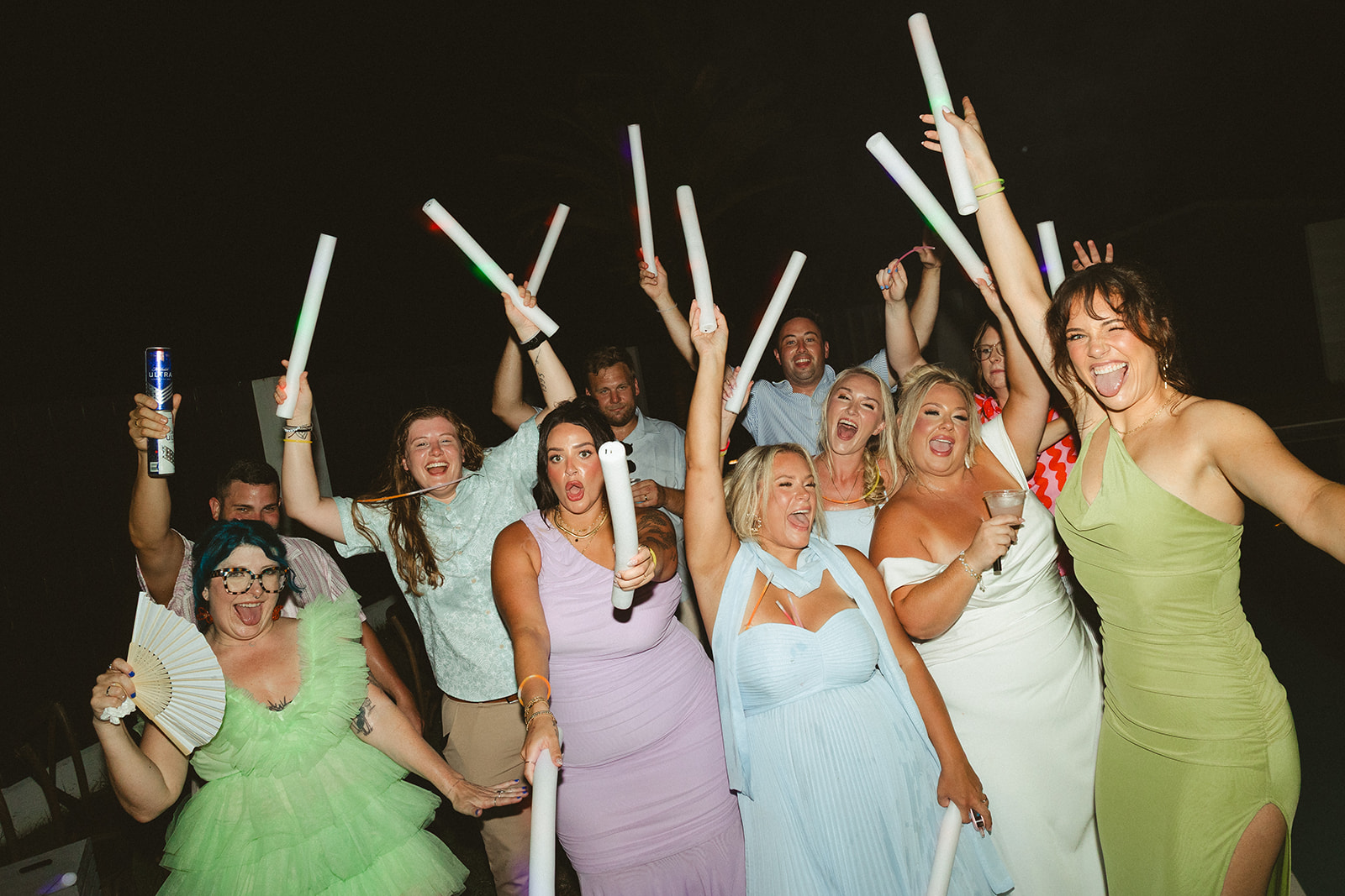 A wedding party cheering at a florida beach wedding reception