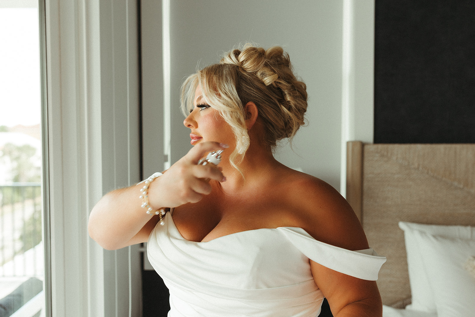 A bride spraying perfume on before her wedding