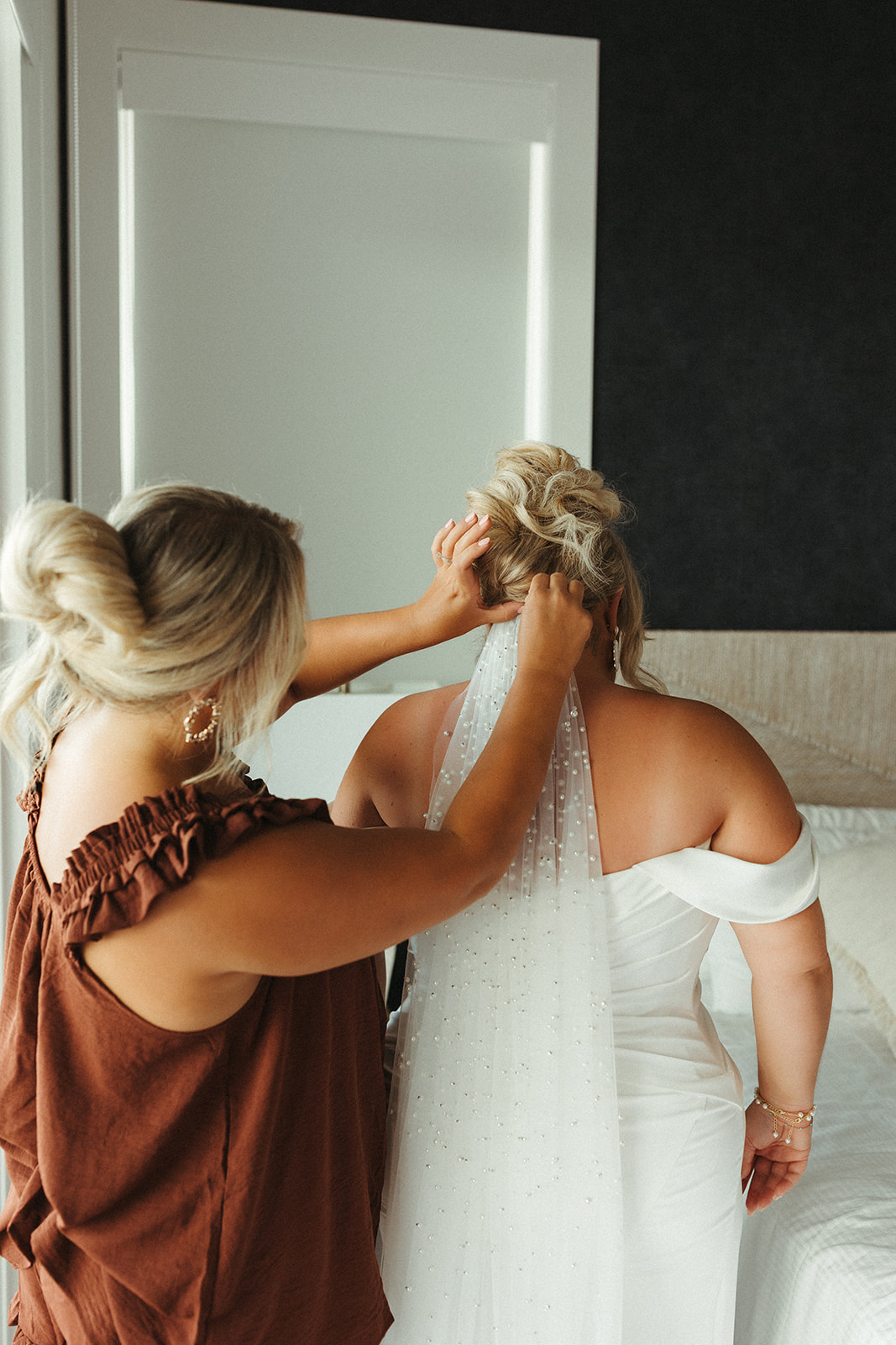 A bride having her wedding veil put in