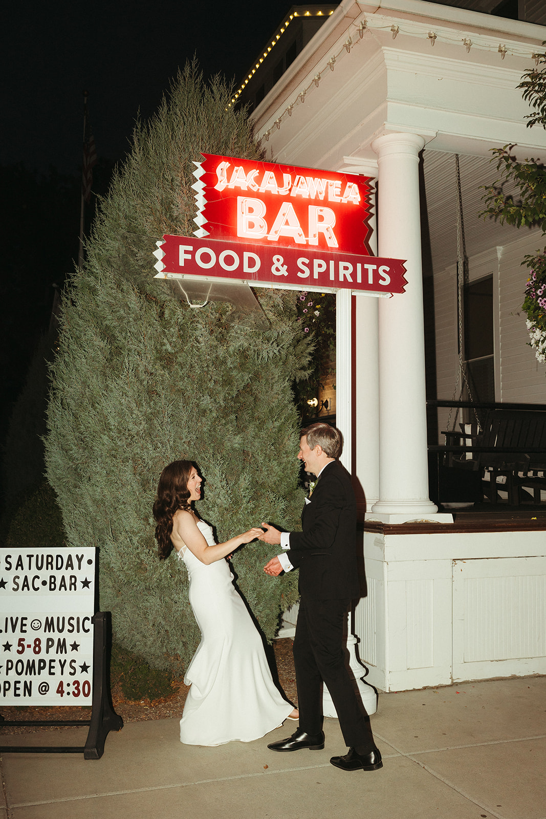 A bride and groom taking wedding photos outside at their wedding venue