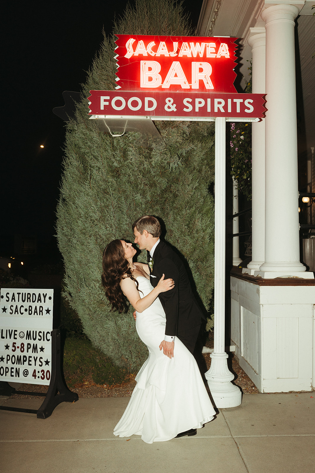 A bride and groom taking wedding photos outside at their wedding venue
