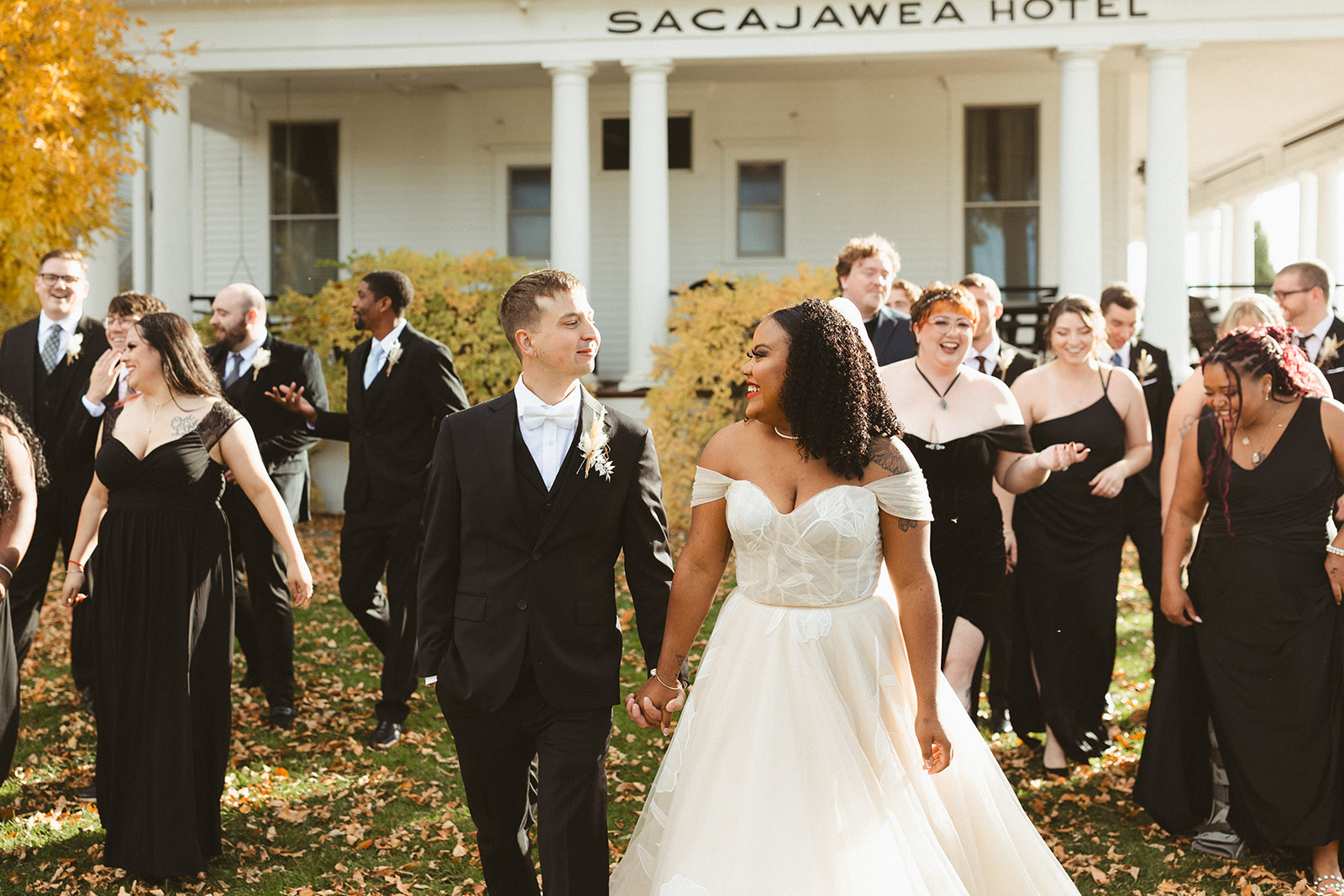 A wedding party walking towards the camera on the lawn of the Sacajawea hotel