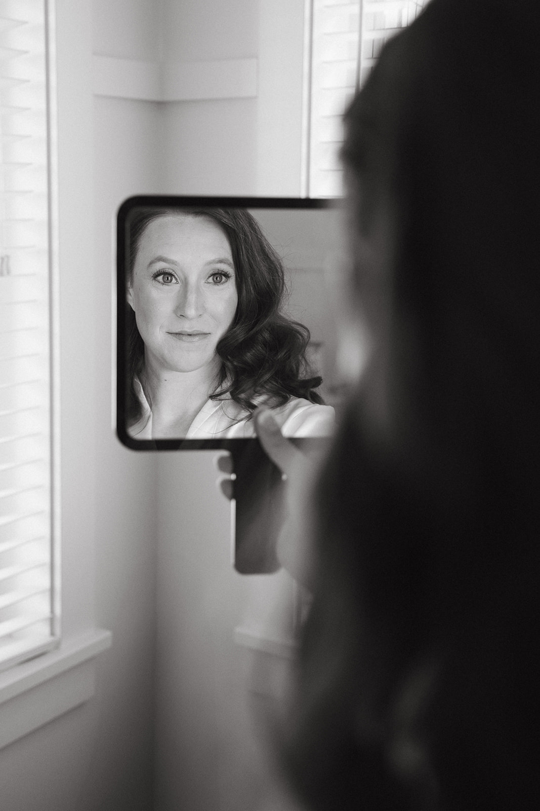 A bride looking in the mirror while getting ready for her wedidng