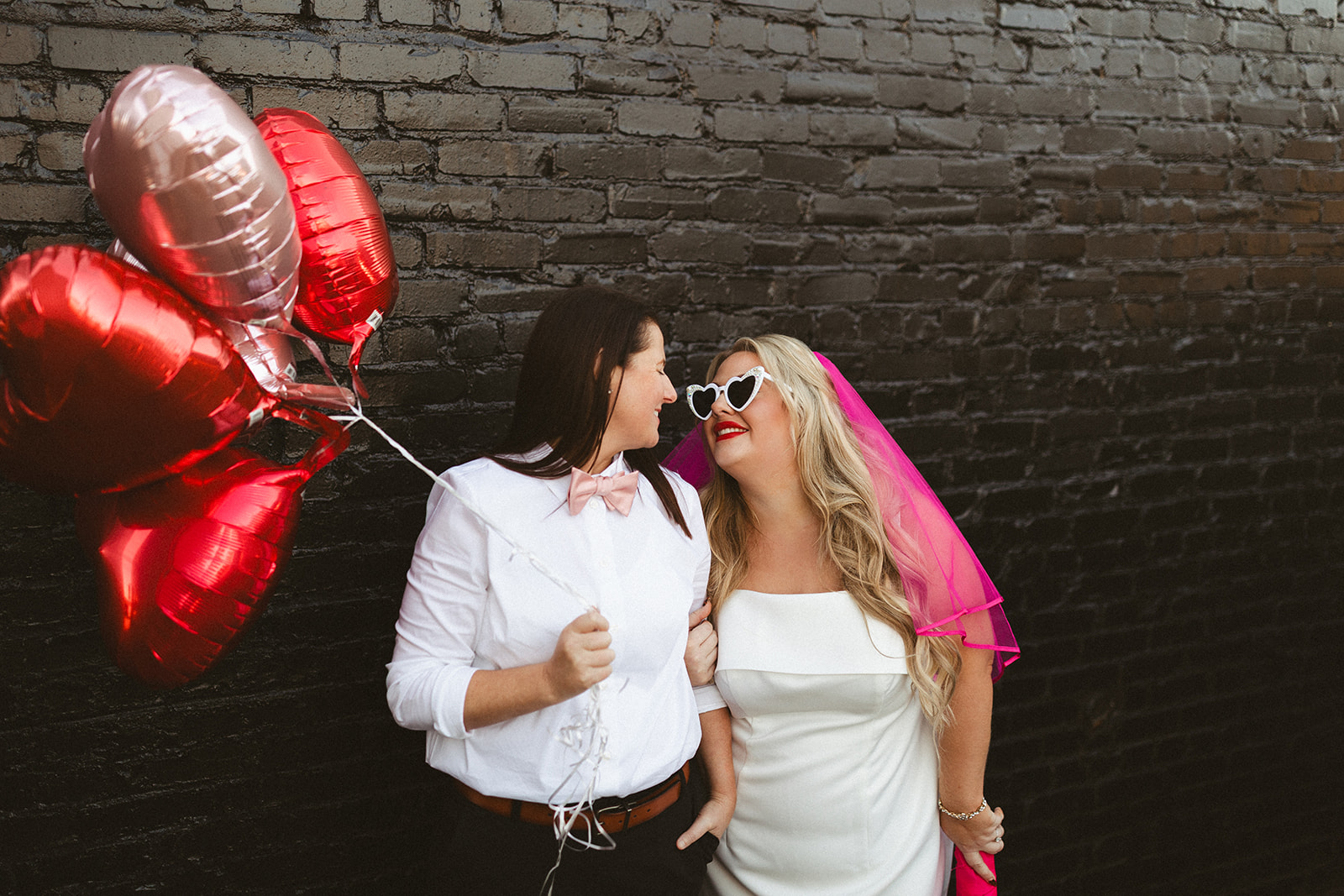 Two brides posing for wedding photos from a wedding with unique wedding ideas