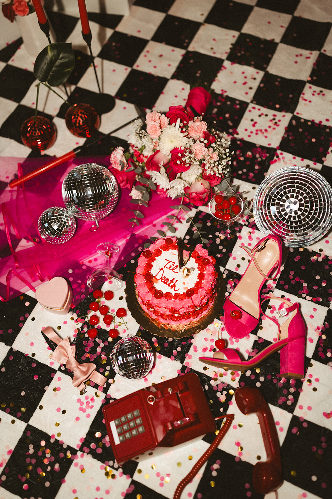 A wedding flat lay with tons of unique wedding ideas, like hot pink shoes and veils and disco balls