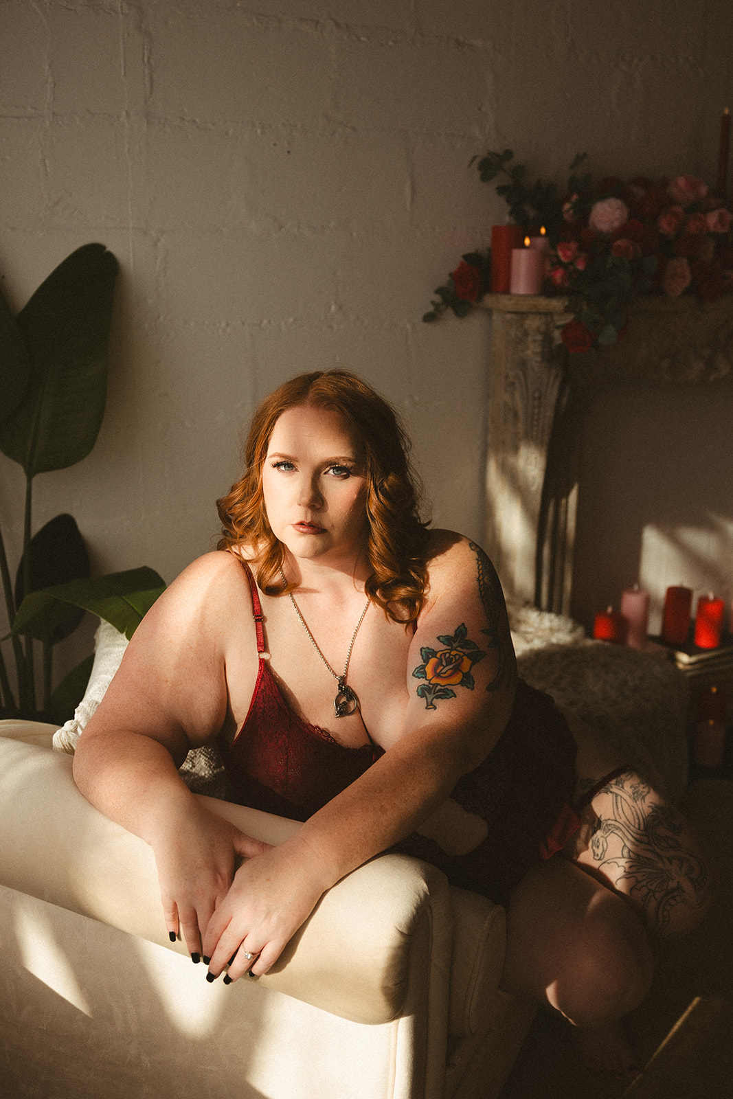 A woman posing for boudoir photos in a valentines day setup