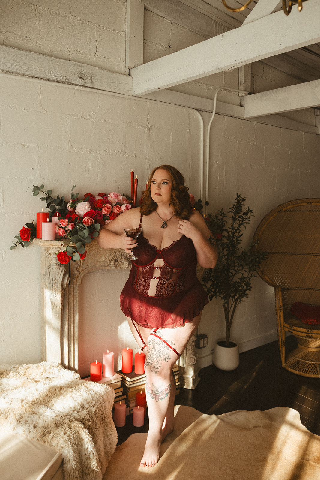 A woman posing for boudoir photos in a valentines day setup