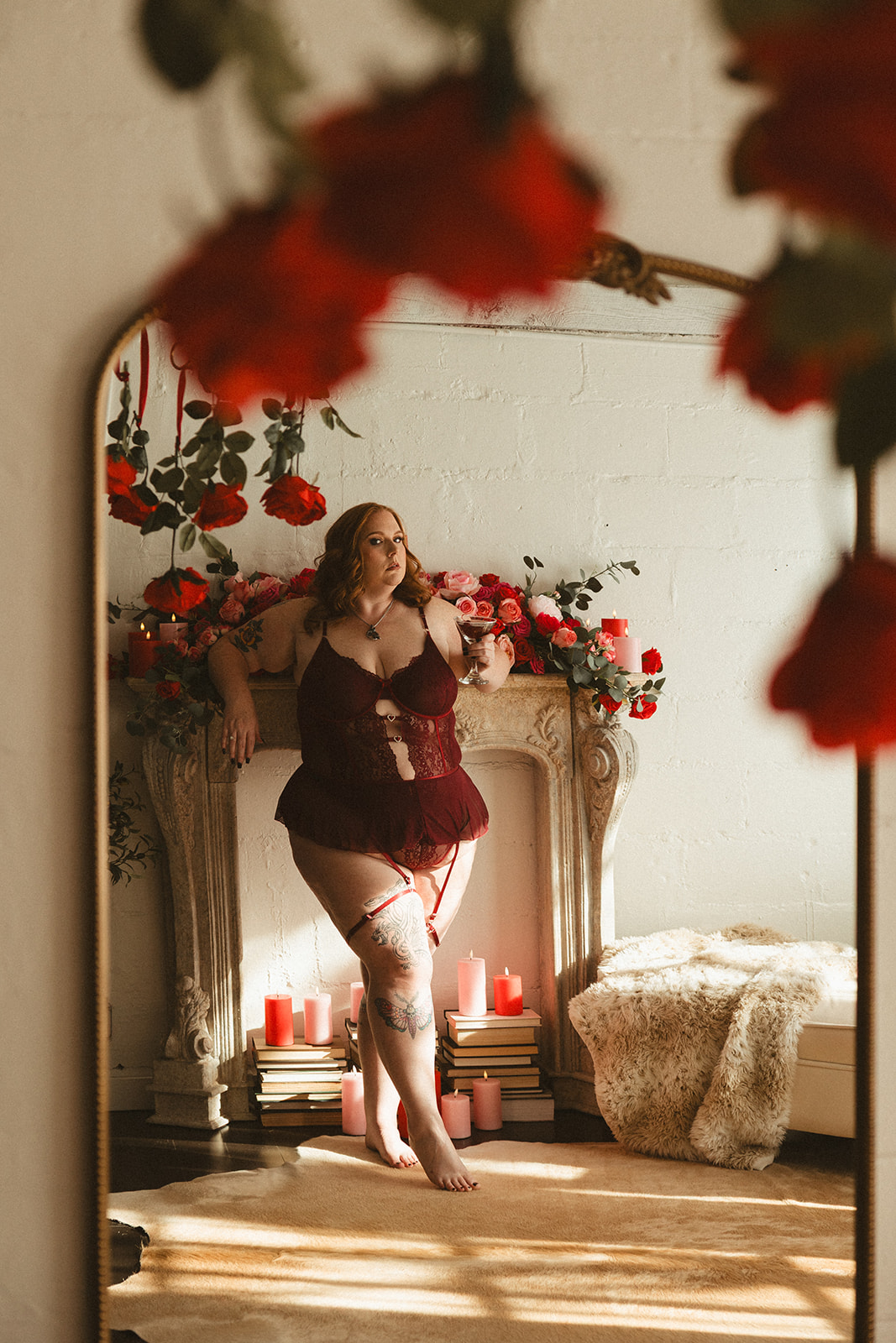 A woman posing for boudoir photos in a valentines day setup