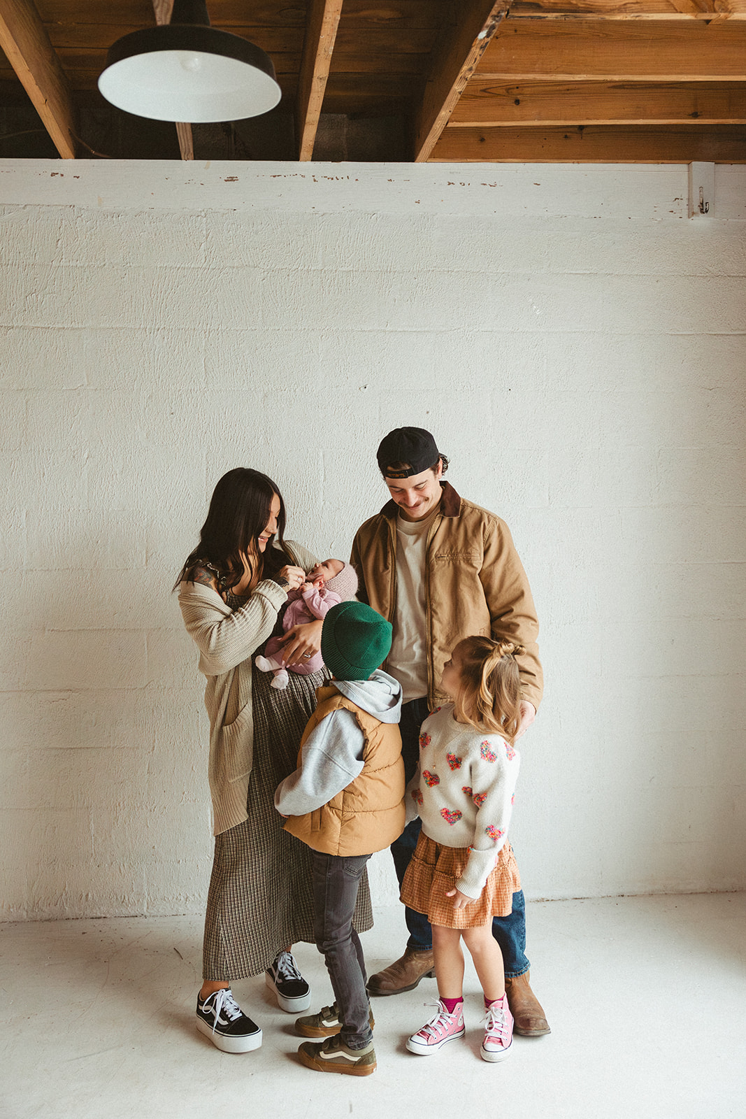 A family posing for studio family photos in front of a white wall