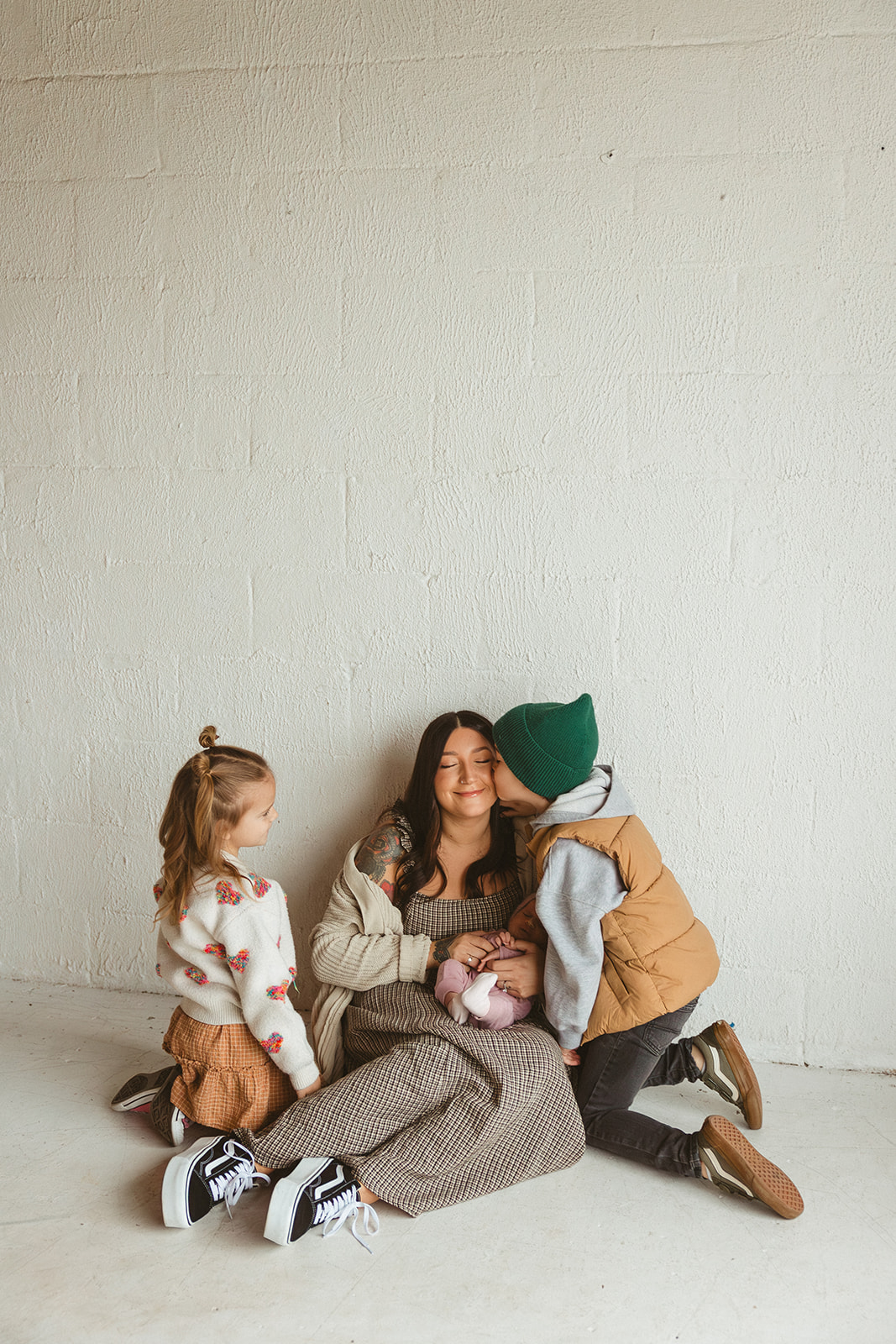 A boy kissing his mom on the cheek during family photos