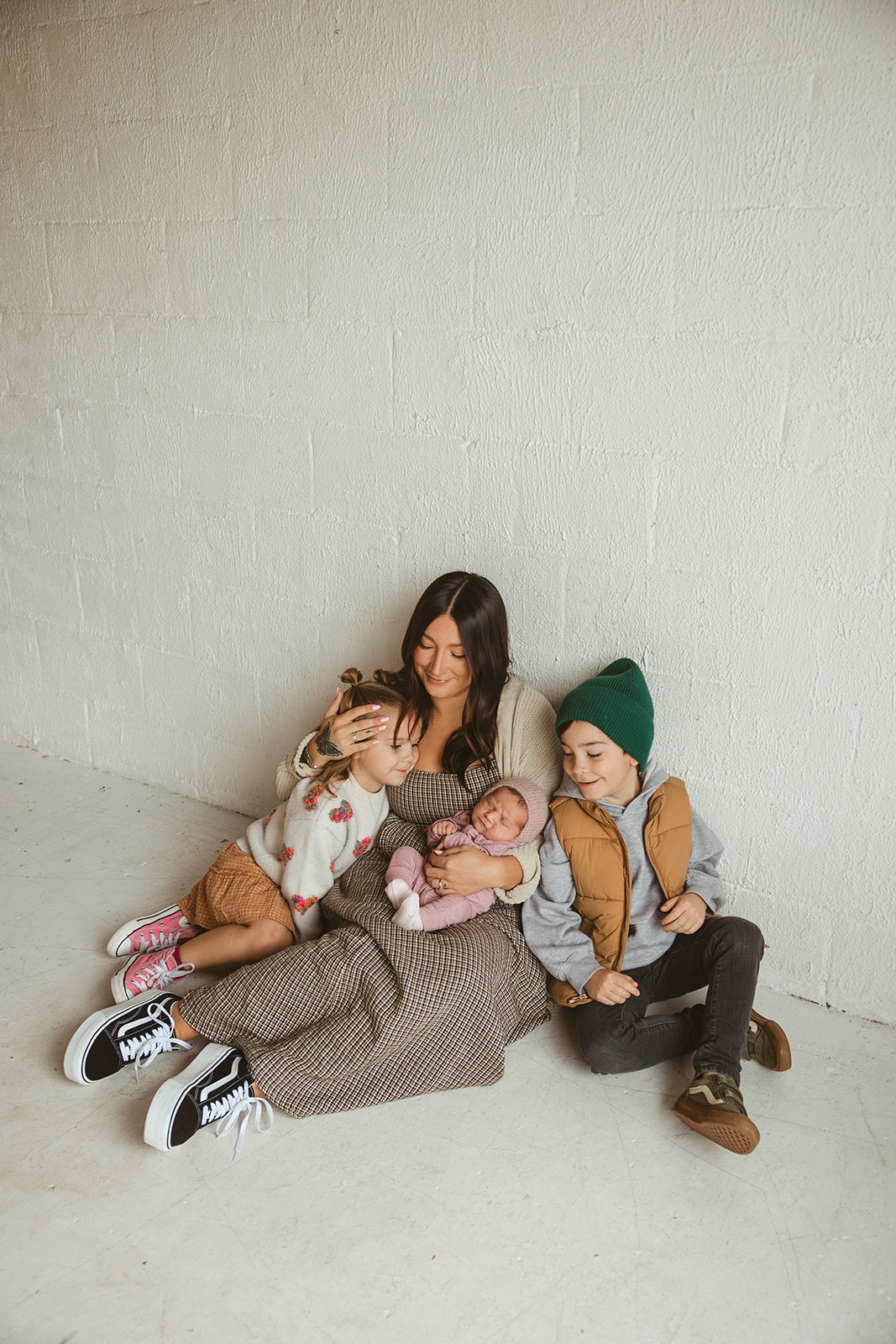 A family sitting on the ground of a studio