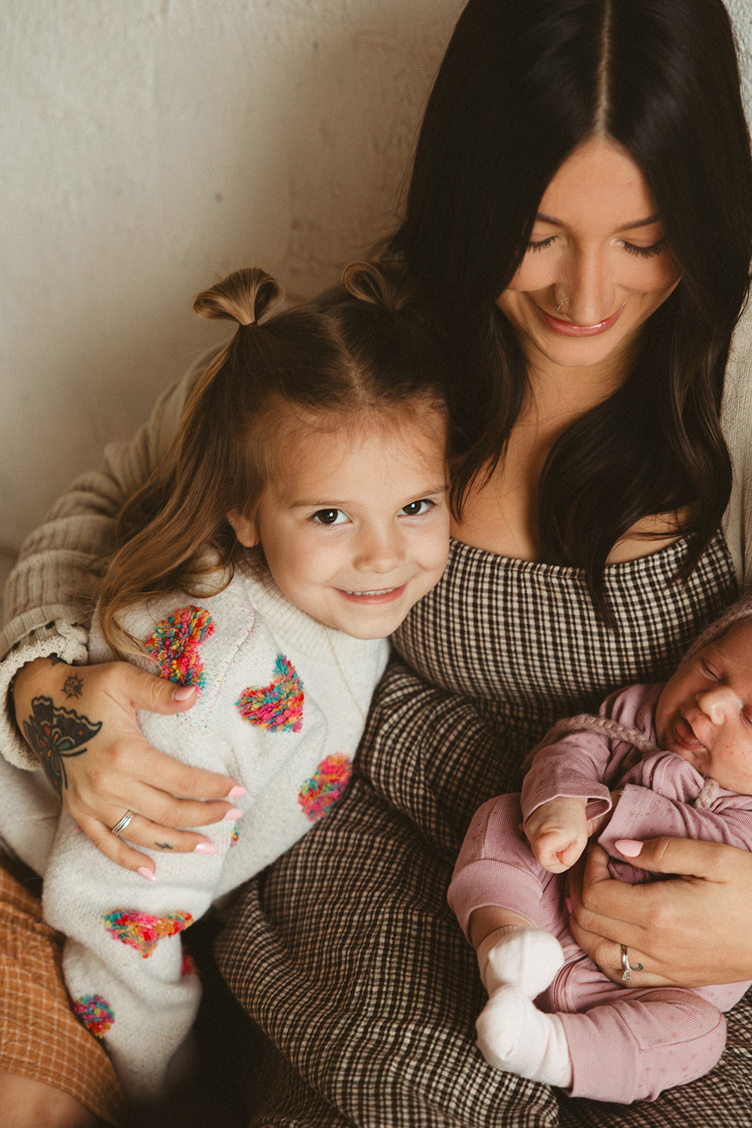 A little girl snuggling with her mom smiling at the camera